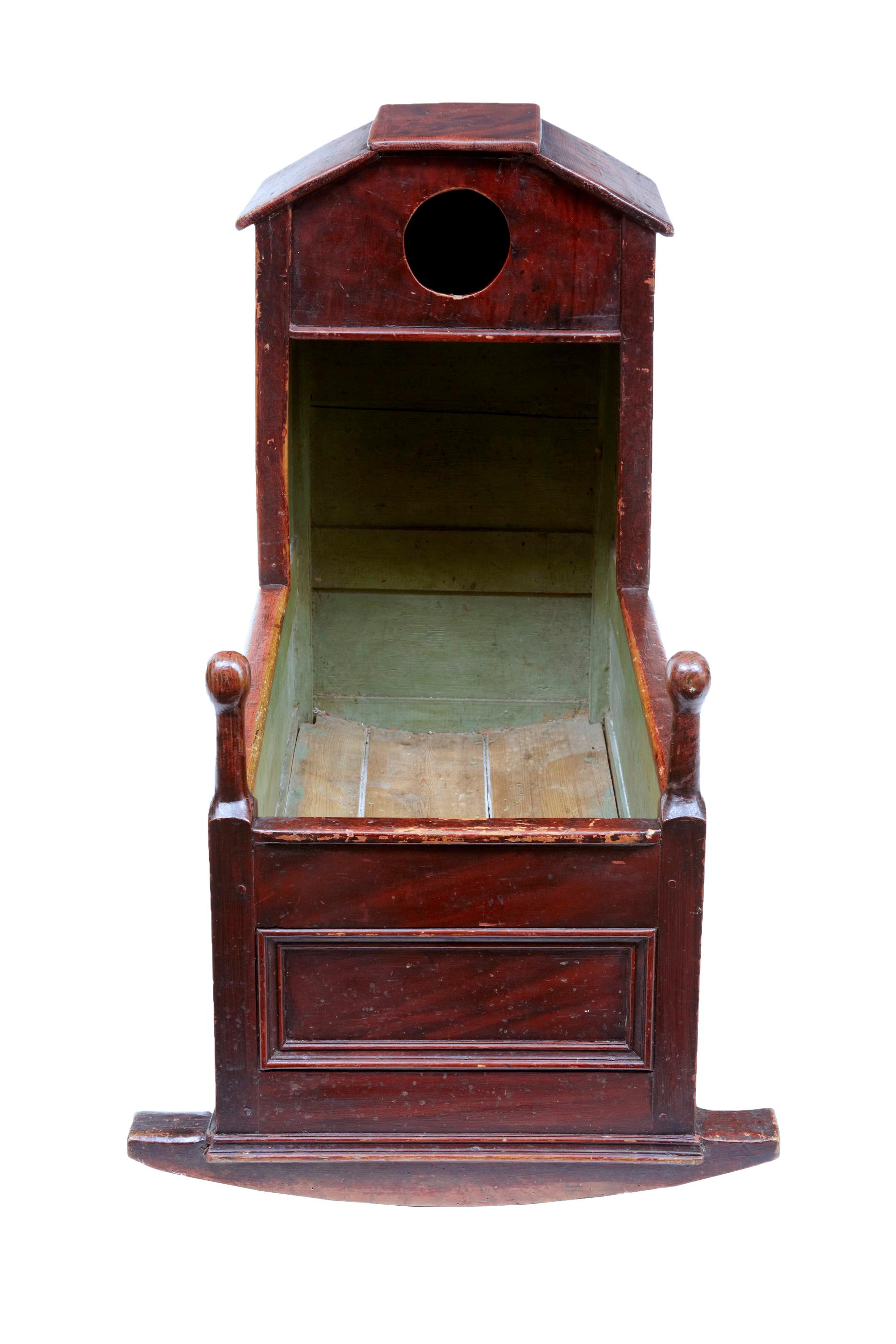 19th century painted pine child's cradle, circa 1870.

Hand painted decorative piece, ideal for use today as a display item. Canopy roof with pigeon hole, turned finials on the end.

Expected losses to paint, surface marks to wood work.
 