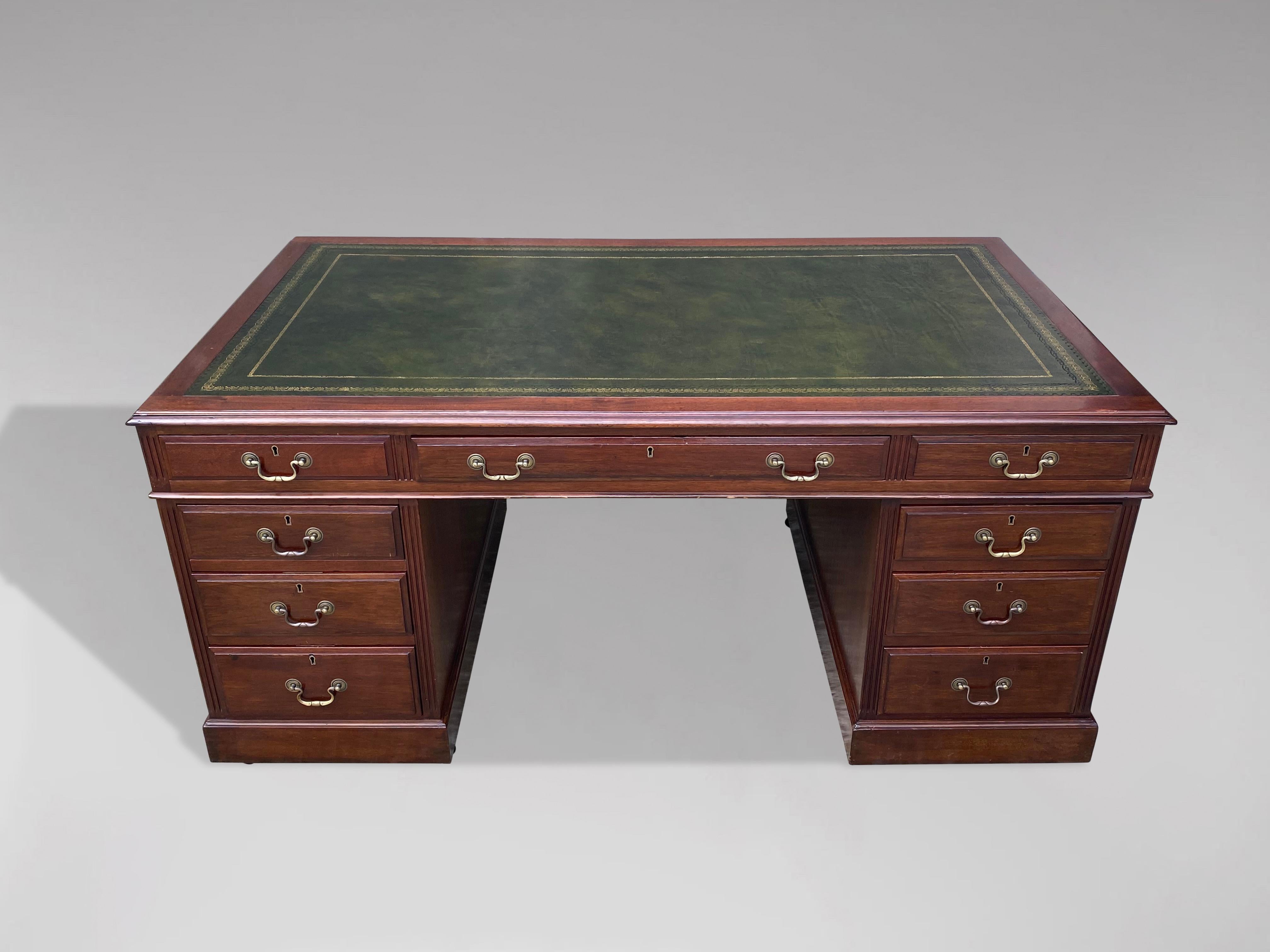 A fine quality, large late 19th century mahogany desk with nine mahogany lined drawers. The quality green tooled leather inset to top with thumb moulded edge, above one long and two short drawers over two pedestals, each with three graduated drawers
