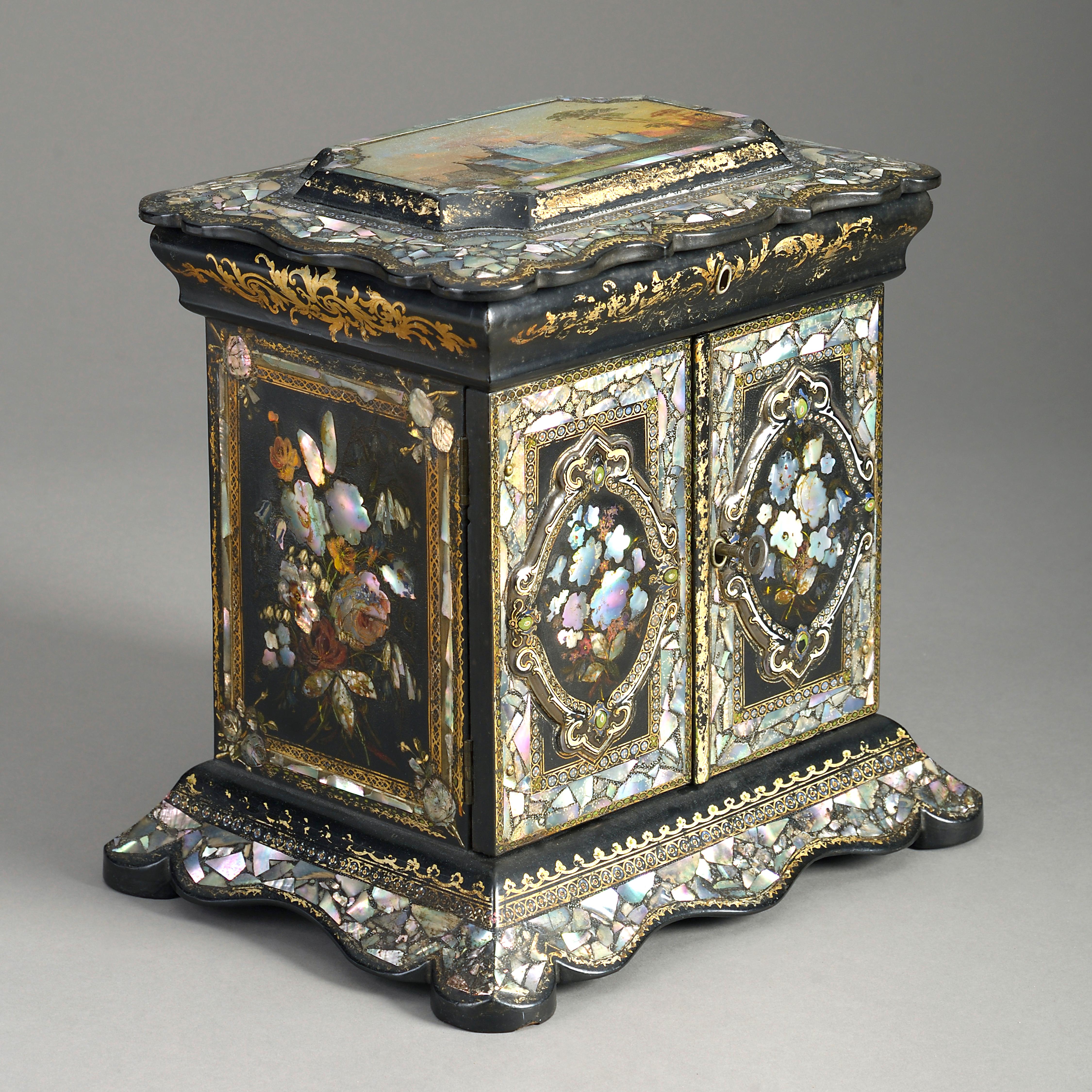 A mid-19th century Victorian Period black japanned sewing box, of architectural form, decorated throughout with mother of pearl floral veneers and gilded scrollwork, having two doors, opening to reveal shelves.