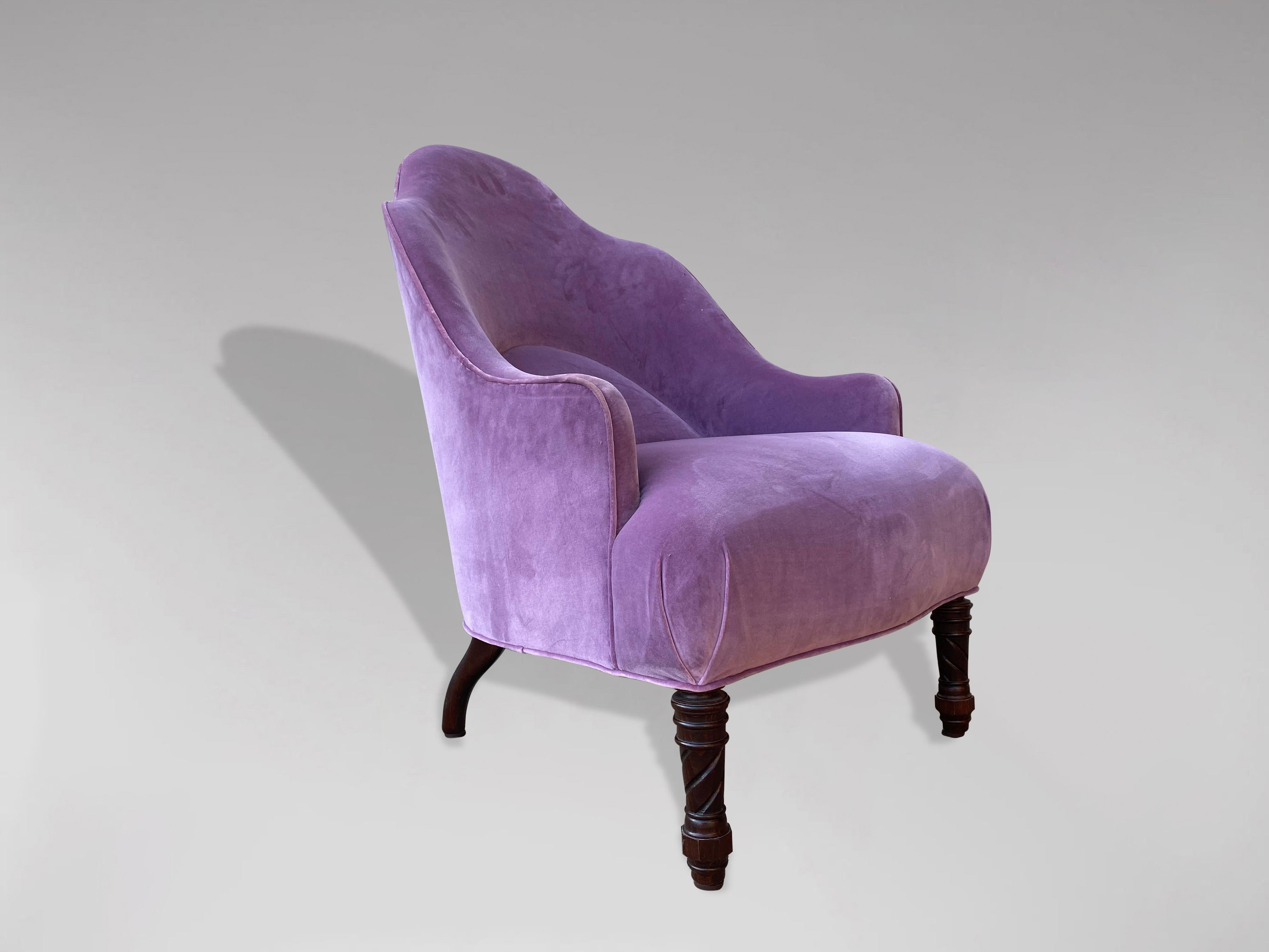 Très beau fauteuil d'époque victorienne en forme de baignoire à haut dossier bouclier du XIXe siècle. Reposant sur des pieds tournés et sculptés, il est tapissé d'un tissu de velours violet clair. Grande forme avec un dos en forme pour augmenter le