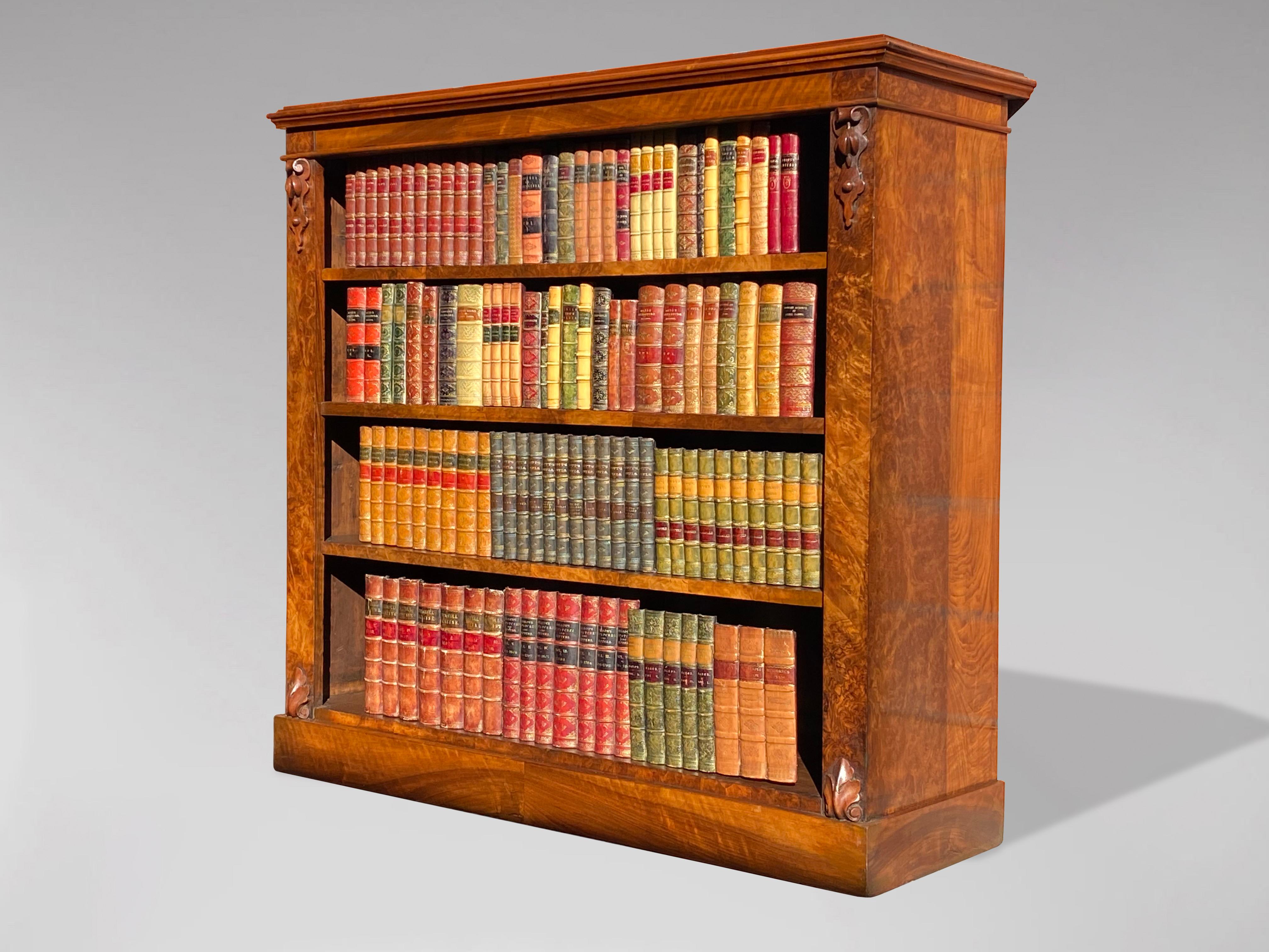 Libreria a giorno in noce di epoca vittoriana del XIX secolo, con piano rettangolare ben modellato, sopra tre ripiani regolabili all'interno, affiancati da capitelli a voluta. Il tutto sollevato su una base a plinto. I fianchi sono in noce figurato