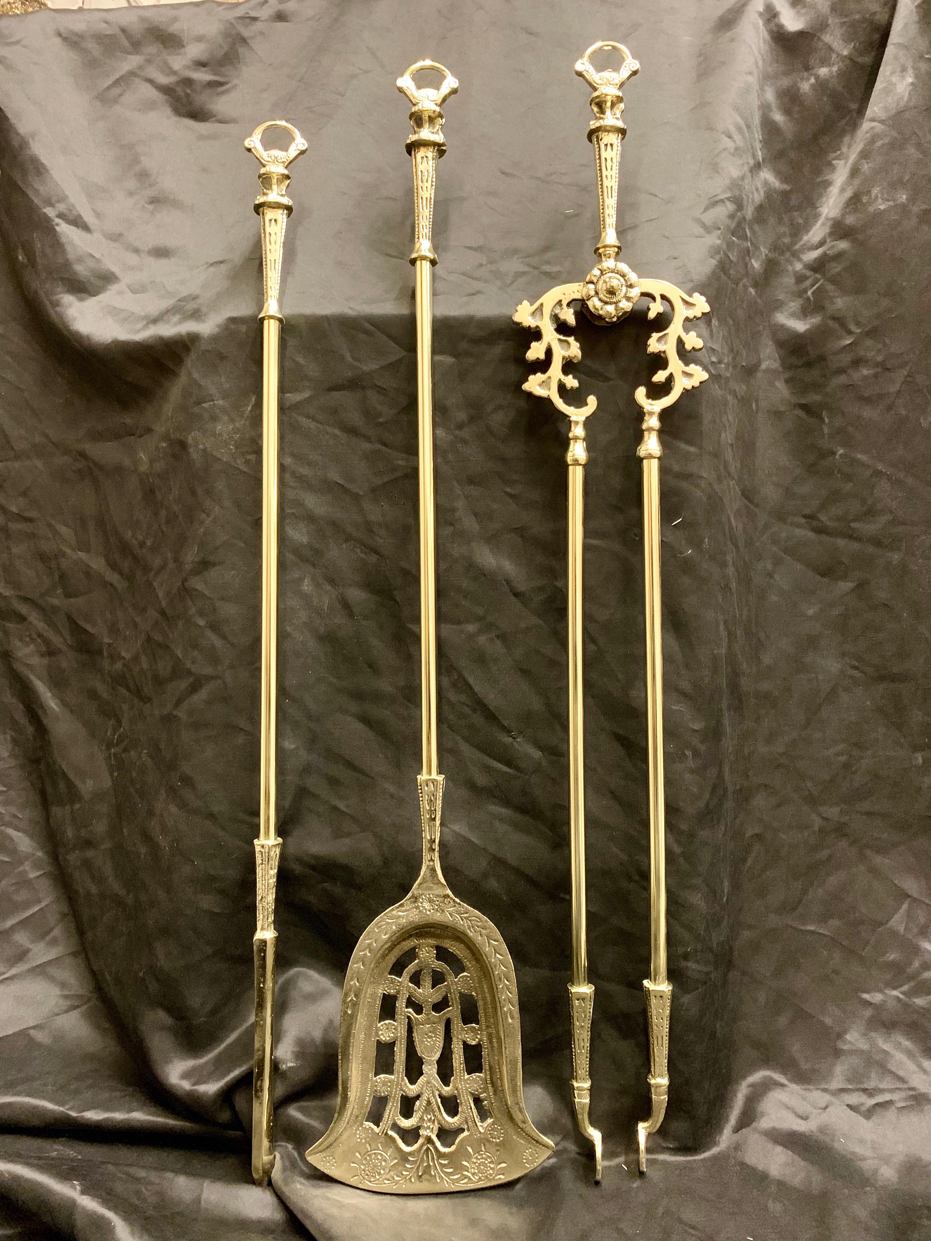 A set of three 19th century Victorian long polished brass fire irons consisting of a poker, a decoratively cast and pierced shovel with an etched rim, and a pair of tongs with rosette bosses, each with an ornate loop handle, could be hung up or laid
