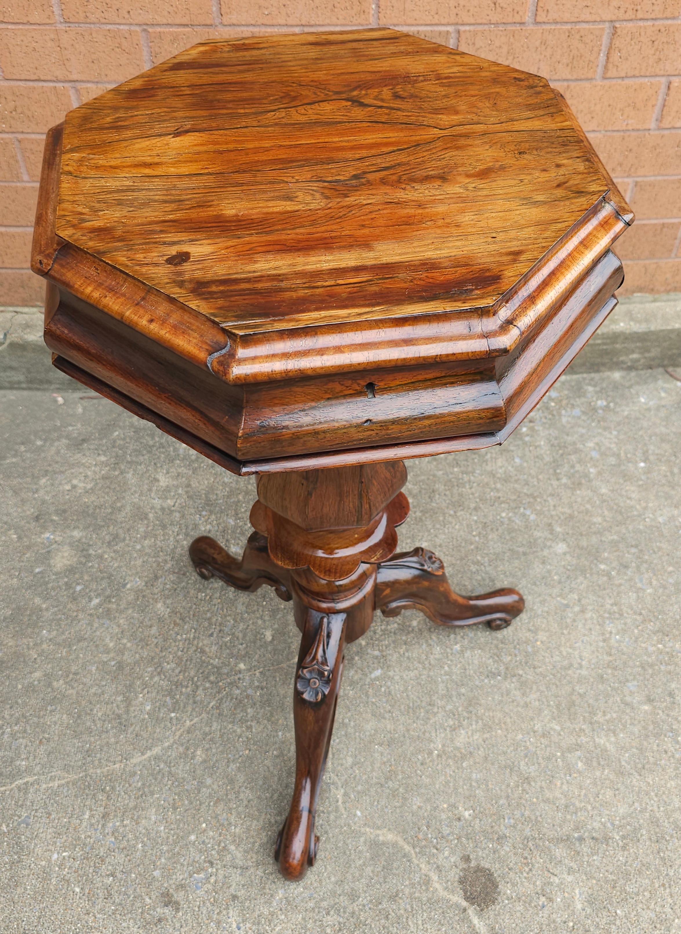 A 19th Century Victorian Rococo Revival Rosewood Tripod Sewing Stand Table. 
The sewing stand opening to view a central crimson jacquard silk pad flanked by four graduated compartments.
Measures 19