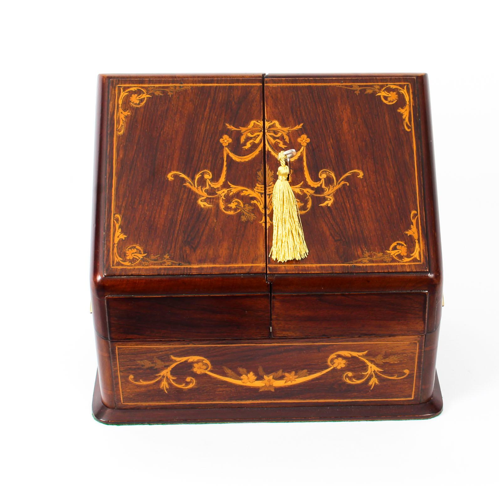 Victorian rosewood, mahogany, marquetry and penwork stationery box , circa 1880

the hinged and divided slant front decorated with ribbon tied swags and scrolls, opening to a compartmented interior and calendar date/year card inserts