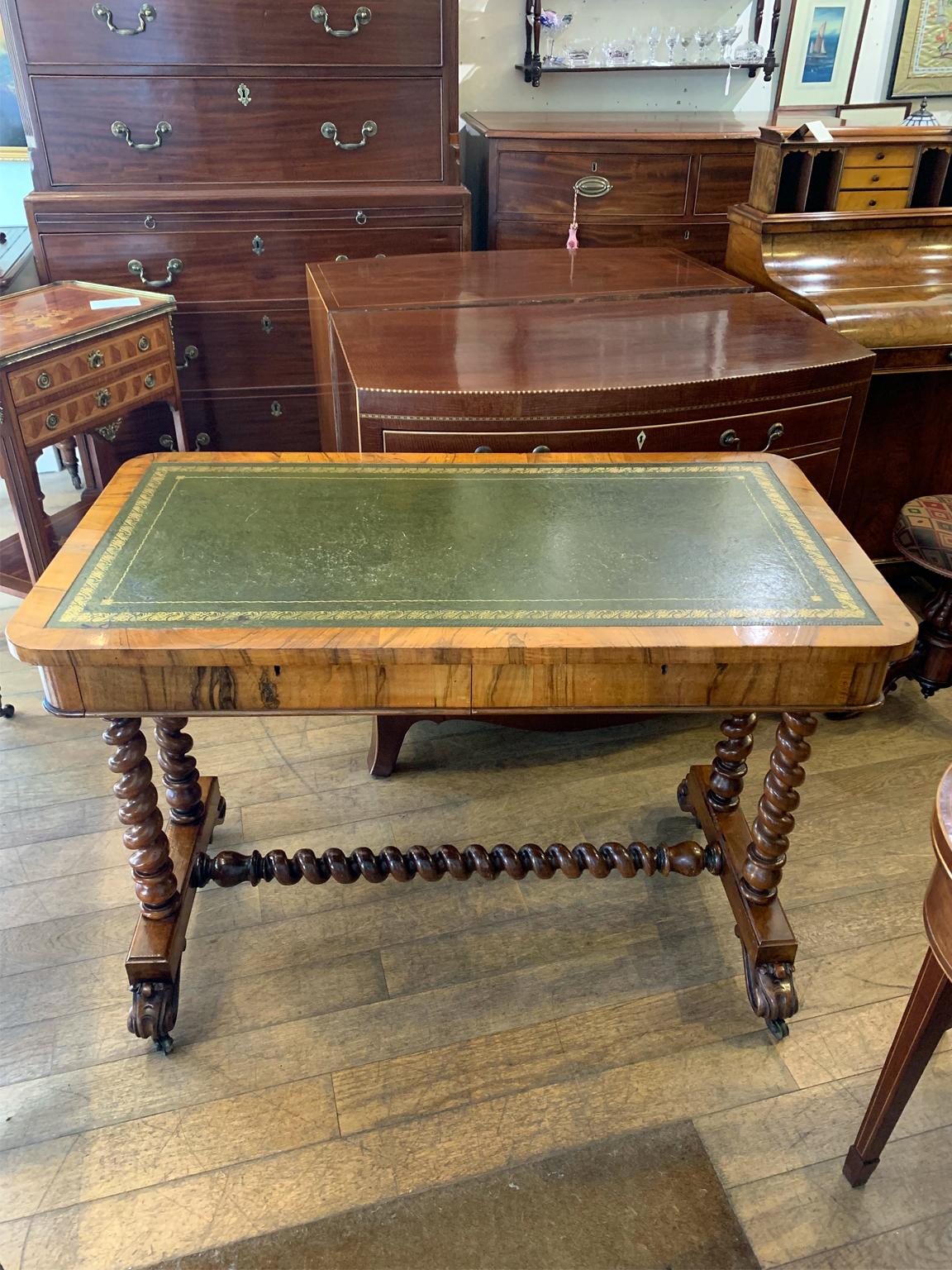 A 19th century Victorian rosewood & mahogany writing table, the top inset with gilt-tooled green leather with two pull out drawers. The turned barley twist supports with finely carved decoration to base on castors.

