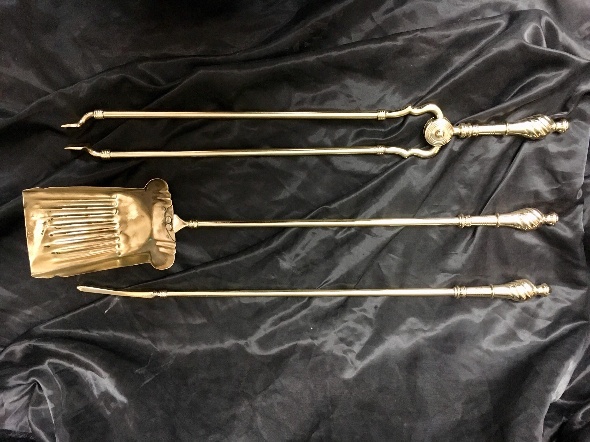 A set of three Victorian 19th century brass fire Irons consisting of a poker, a shovel, and a pair of tongs, each with a spiral and pommel finial handle.

English, circa 1890.