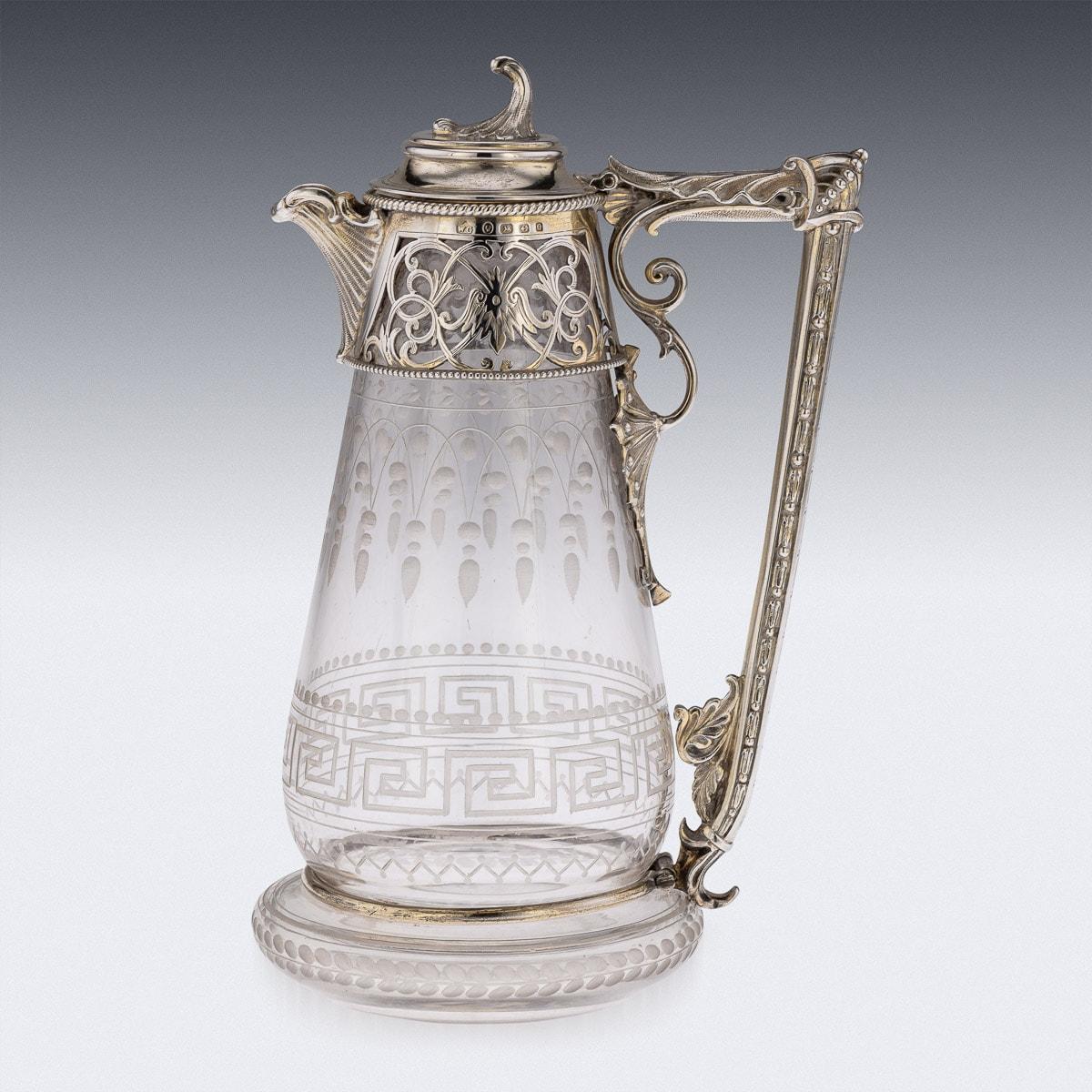 Antique 19th Century Victorian silver mounted & etched glass claret jug, tapering body etched with swag frieze above a Greek key border, applied with a pierced scrolling mount, hinged cover with cast knop, acanthus leaf capped handle. Hallmarked