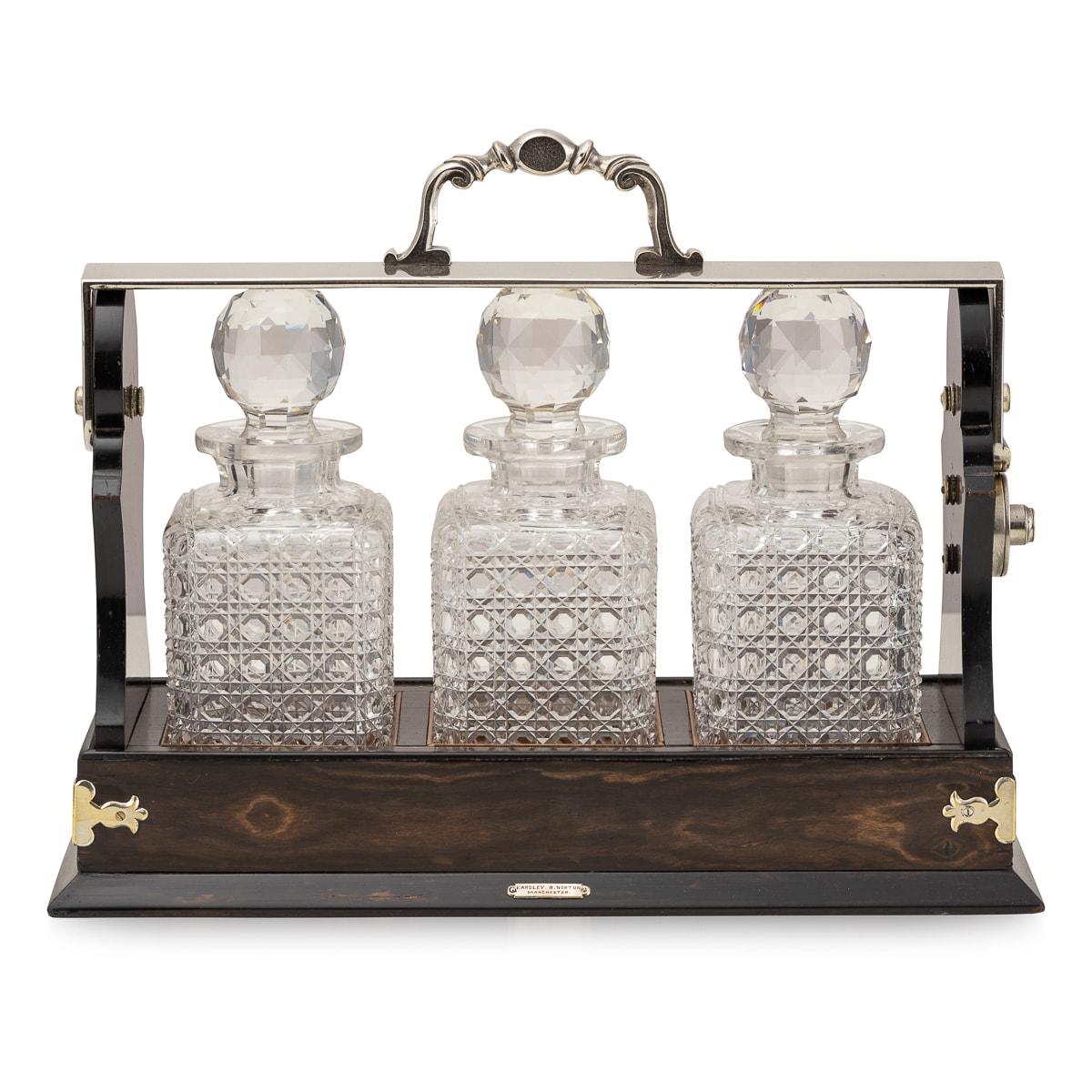 Antique late-19th Century Victorian silver plated mounted on coromandel tantalus, the interior comprising three cut crystal decanters with stoppers.

CONDITION
In Great Condition - No Damage.

SIZE
Height: 32cm
Width: 42cm
Depth: 17cm
