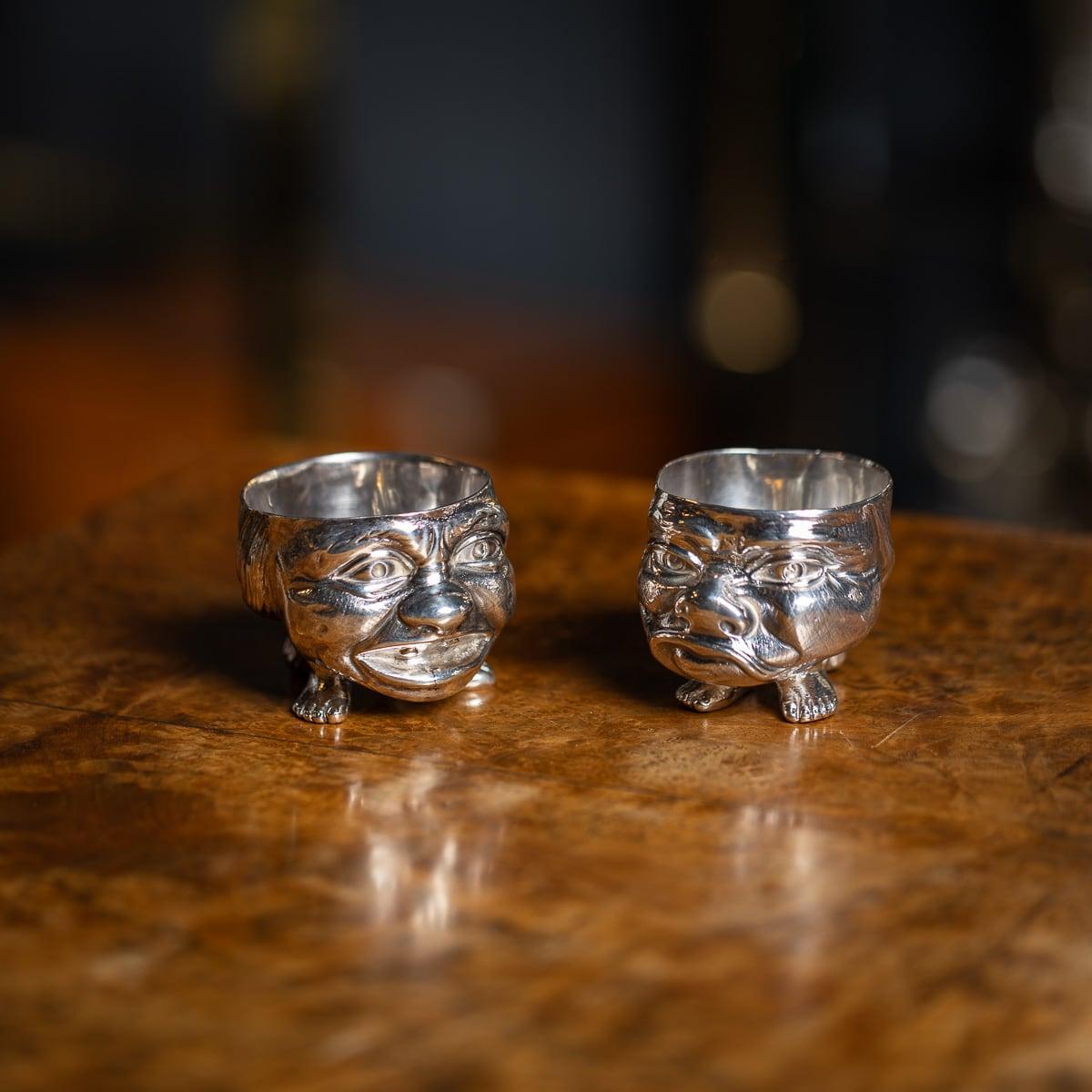 Antique 19th Century Victorian solid silver pair of novelty grotesque salts. Expertly cast and modelled to depict contrasting expressions—one smiling and the other frowning. Hallmarked English silver (925 standard), London, year 1880 (E), Maker's