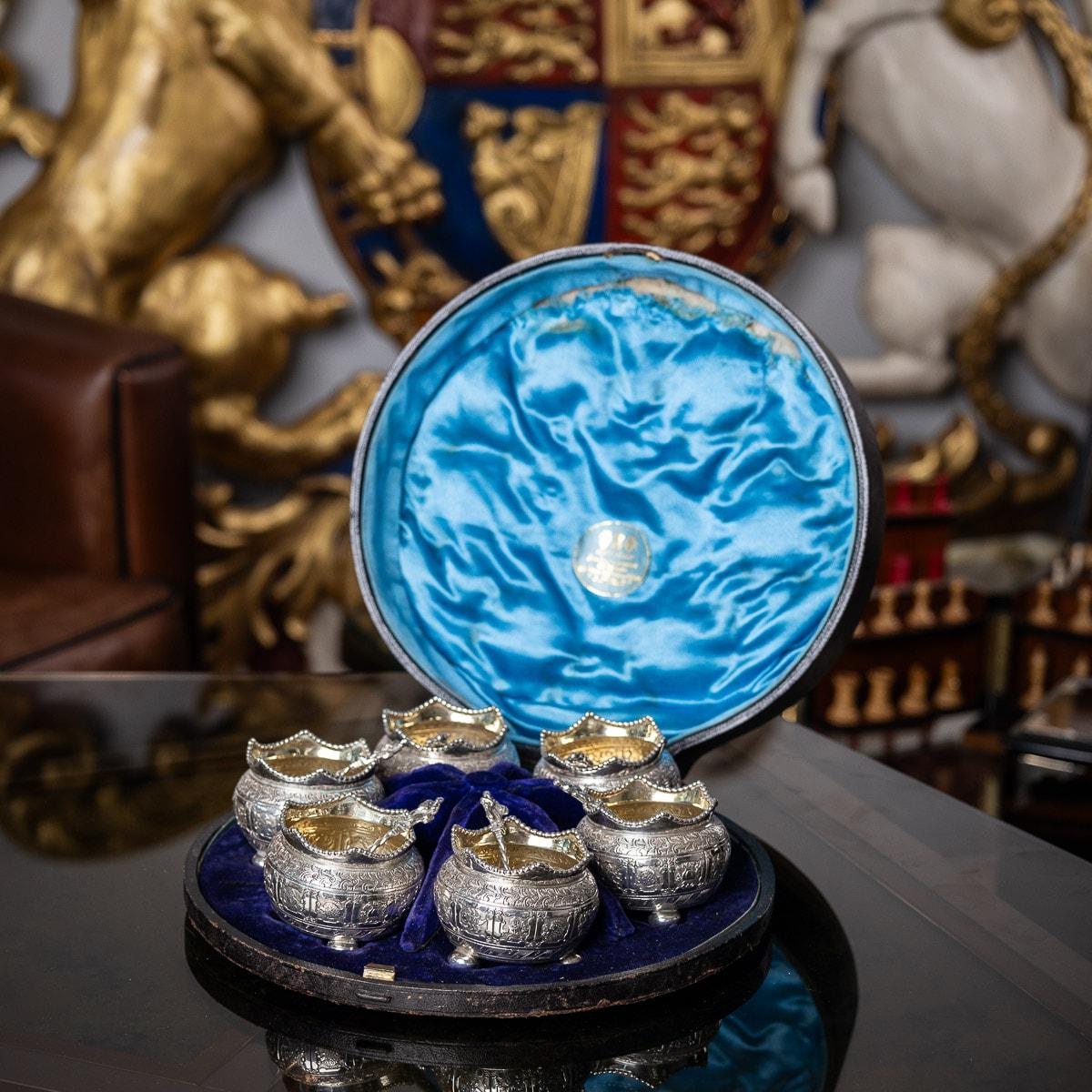 19th century Victorian set of six silver table salts and spoons, each of circular form, on three ball feet, mounted with a beaded crown boarder, parcel gilt inside and engraved with a lovely band of Burmese inspired zodiac decoration along the body.