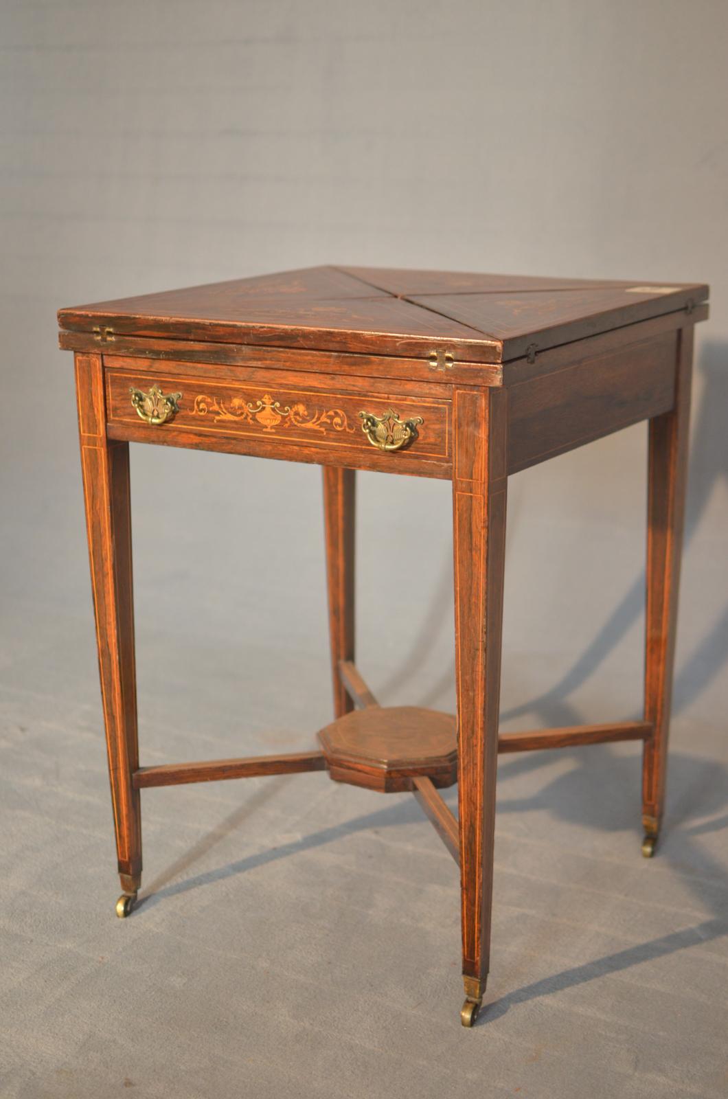 Victorian handkerchief in English rosewood inlaid in the mid-19th century. The table opens by raising the four segments each of which has a glass support. It has a lower drawer. There are wheels for each foot, it is in good condition with some trace