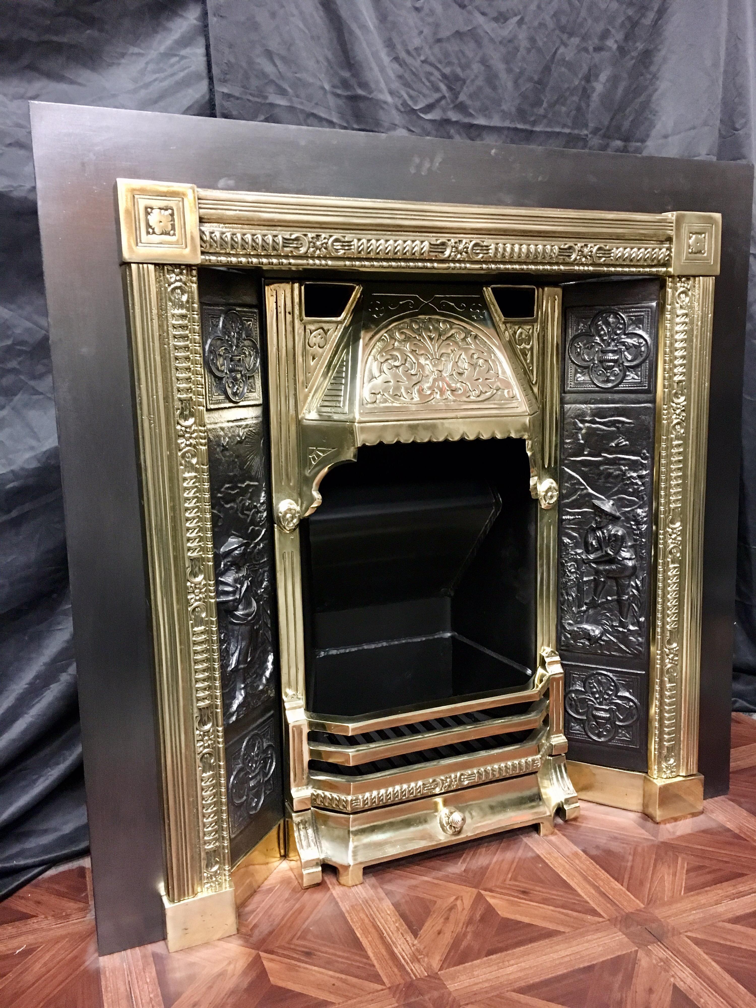 A large 19th century victorian style, cast iron & polished brass fireplace surround insert and grate. A large cast Iron plate surrounds a polished brass frame with capitols, holding a pair of cast panels depicting a dutch country scene, the centre