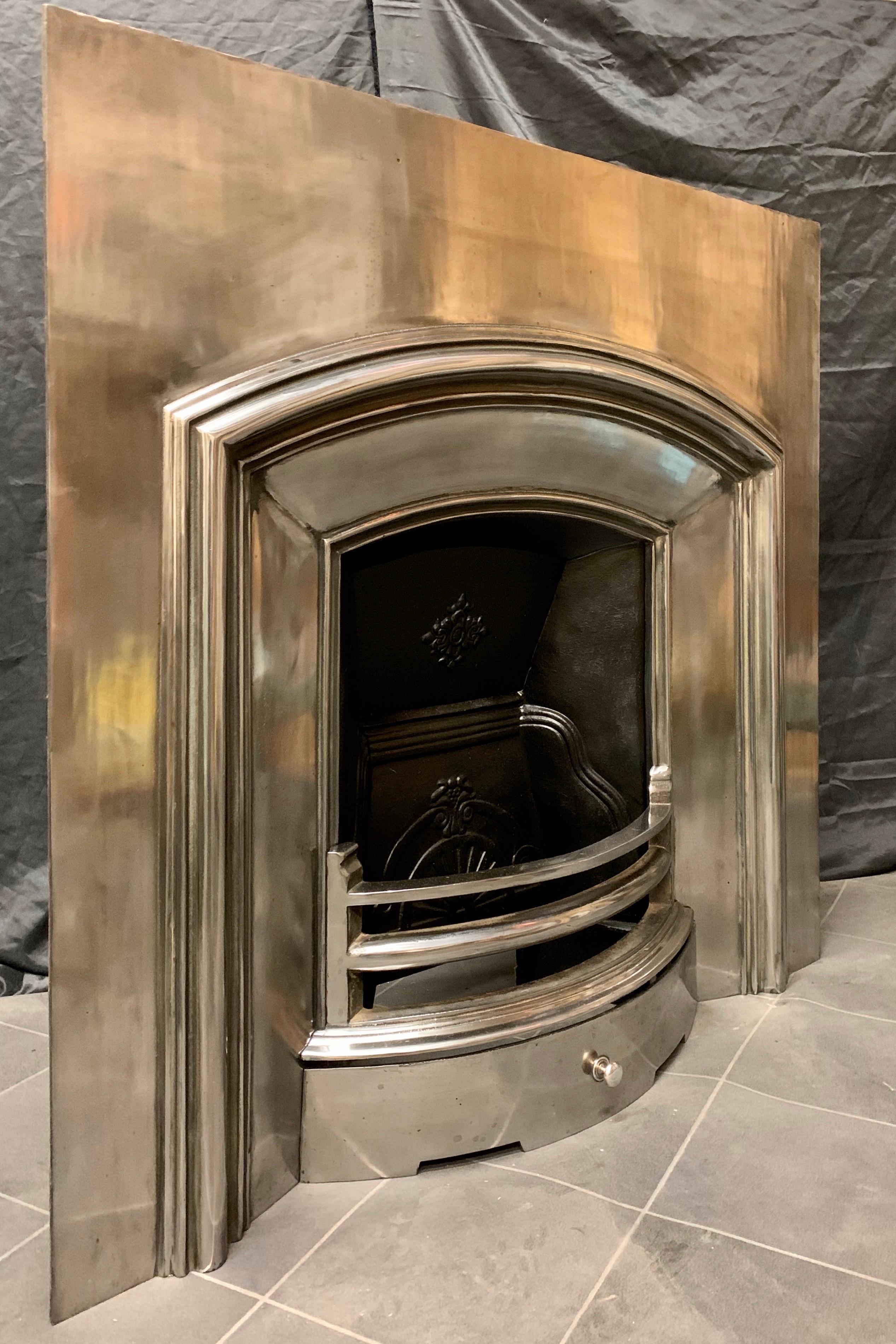 A fully high lighted and polished cast iron 19th century style Victorian slow arch fireplace insert, a generous polished outer plate with a moulded and raised inner frame housing the curved grate bars and damper plate.