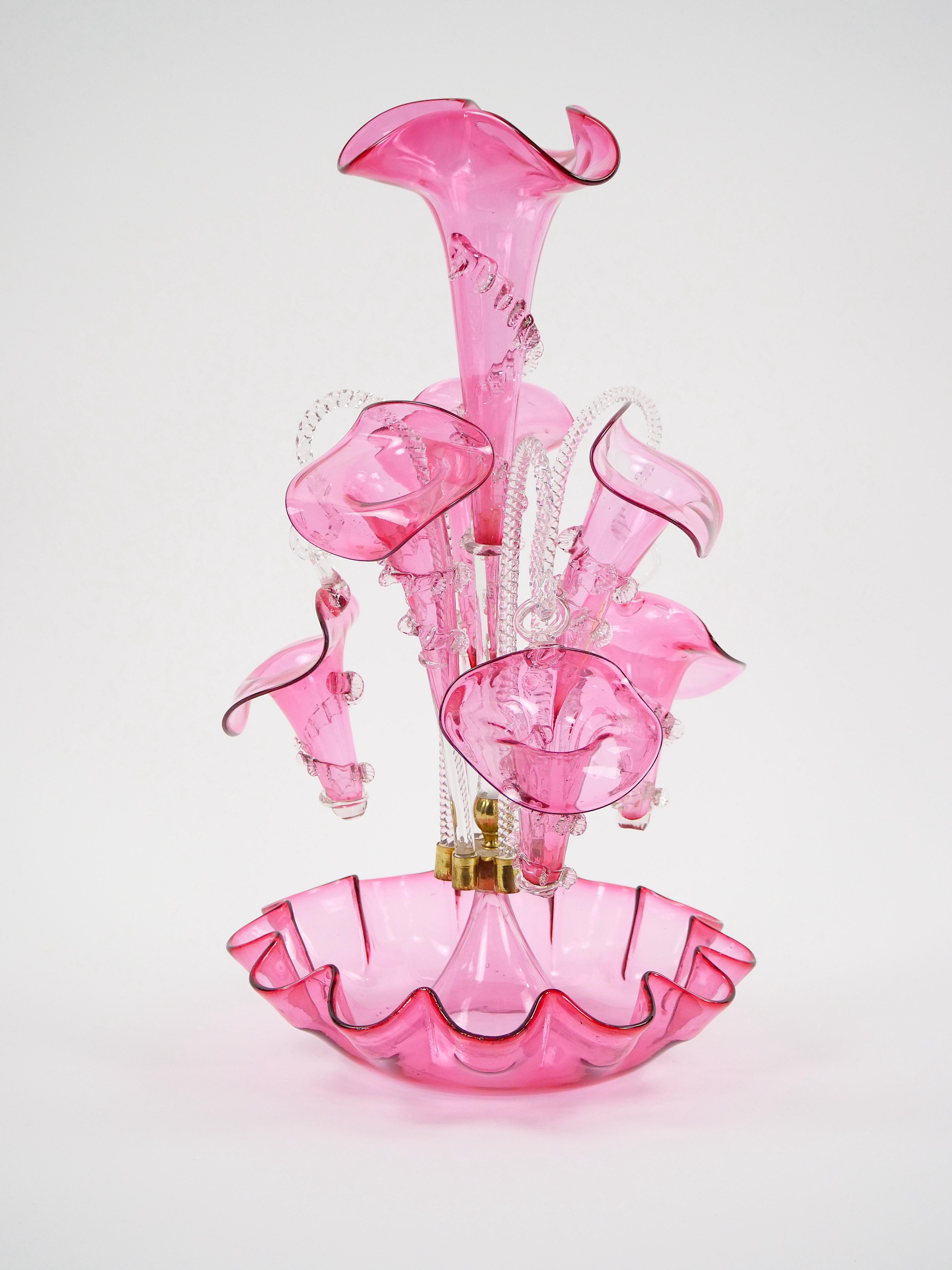 Enhance your living space  with this exquisite 19th Century Victorian-style French Glass  Epergne Centerpiece Vase in a captivating pink hue. A true masterpiece of craftsmanship and elegance, this vase is sure to become the focal point of any room.