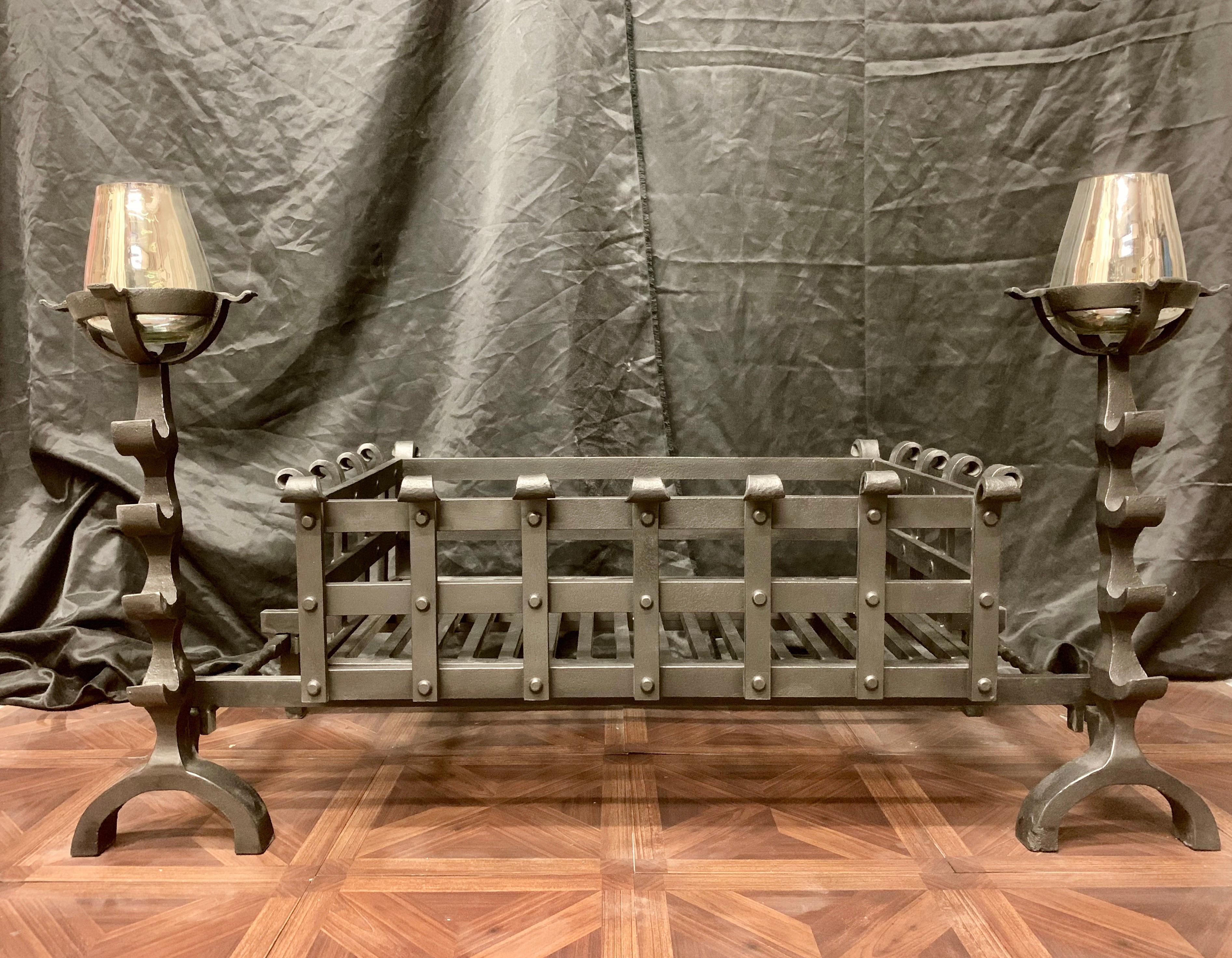 A very large 19th century Victorian style wrought iron fireplace grate, a pair of tall fire dogs with tool rests and circular cup warming holders play host to a very large riveted central fire basket with a generous burning area- scrolls to
