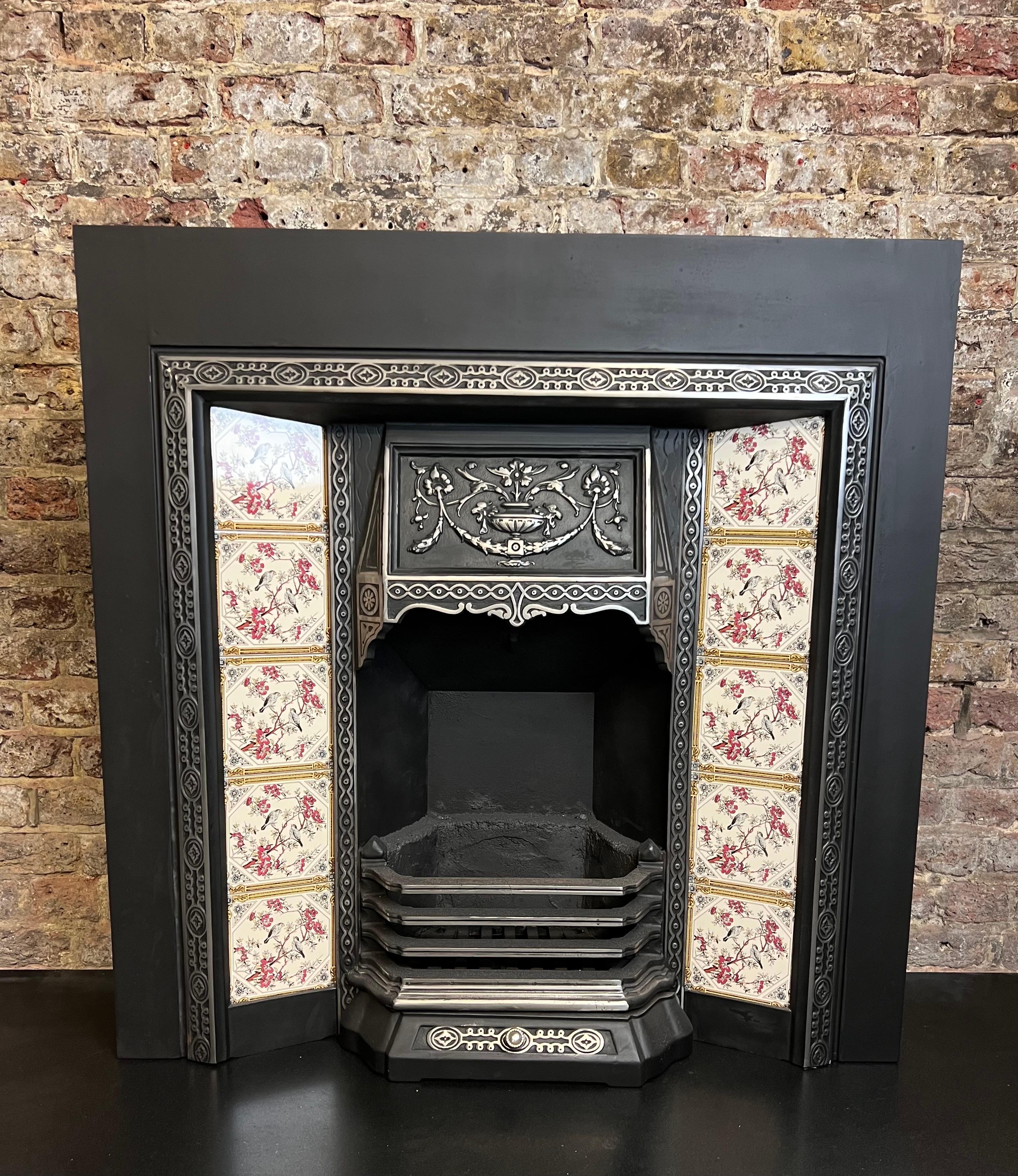 19th Century Cast Iron Tiled Fireplace Insert Design.
Victorian Style Fireplace Design With Swags & Floral Bouquet Canopy Hood & Patterned Trim. Complete With Fireback, Front Bars & Grate. Recently Salvaged From A London Town House And Restored To A