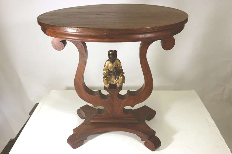 A very handsome 19th century American Victorian mahogany table upon which lower shelf sits a very rare and special bronze sculpture of a fisherman holding a sea shell. 
An enchanted table to bring good luck!!

Provenance: From the Edith Hale