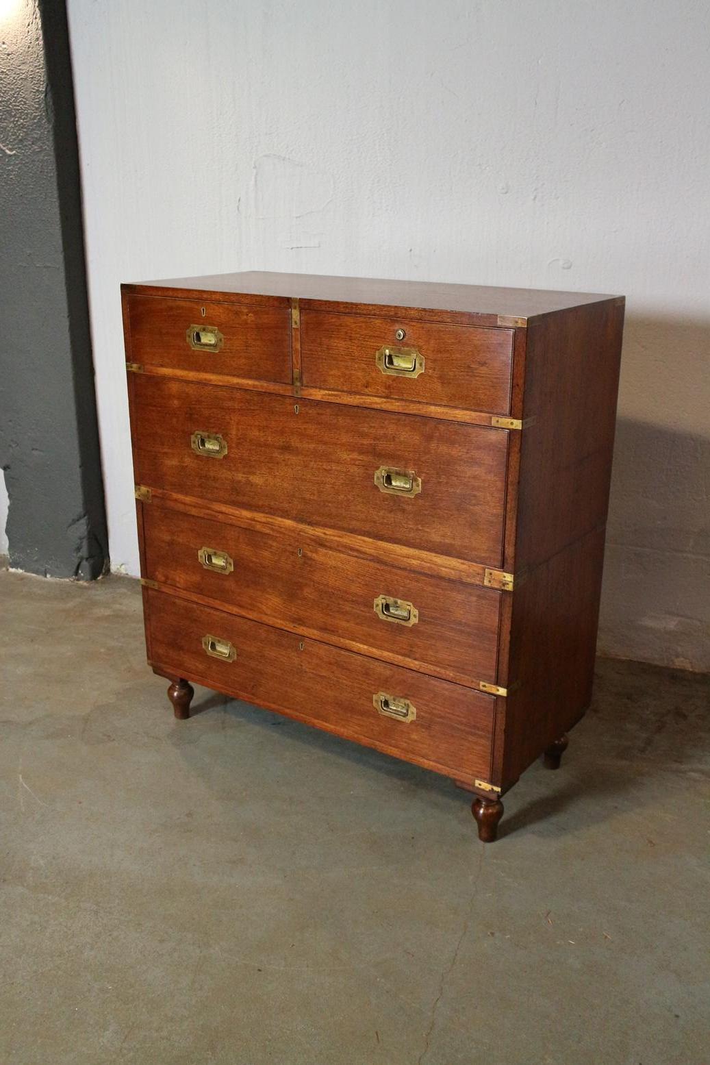 Antique teak campaign chest of drawers from the Victorian era. Nice warm color. Consisting of 2 parts. The cabinet is fitted with flush drawer pullers, brass corners and removable feet. All this to make transport easy and to protect against