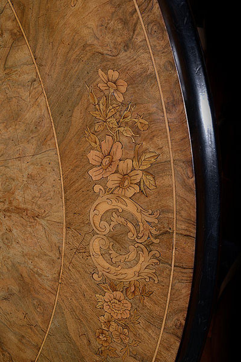 A large Victorian walnut and satinwood marquetry tilt-top table with a circular top.

The figured walnut top with a circular naturalistic floral marquetry design to the centre.

The outer edge with deep crossbanding and floral marquetry.

The whole