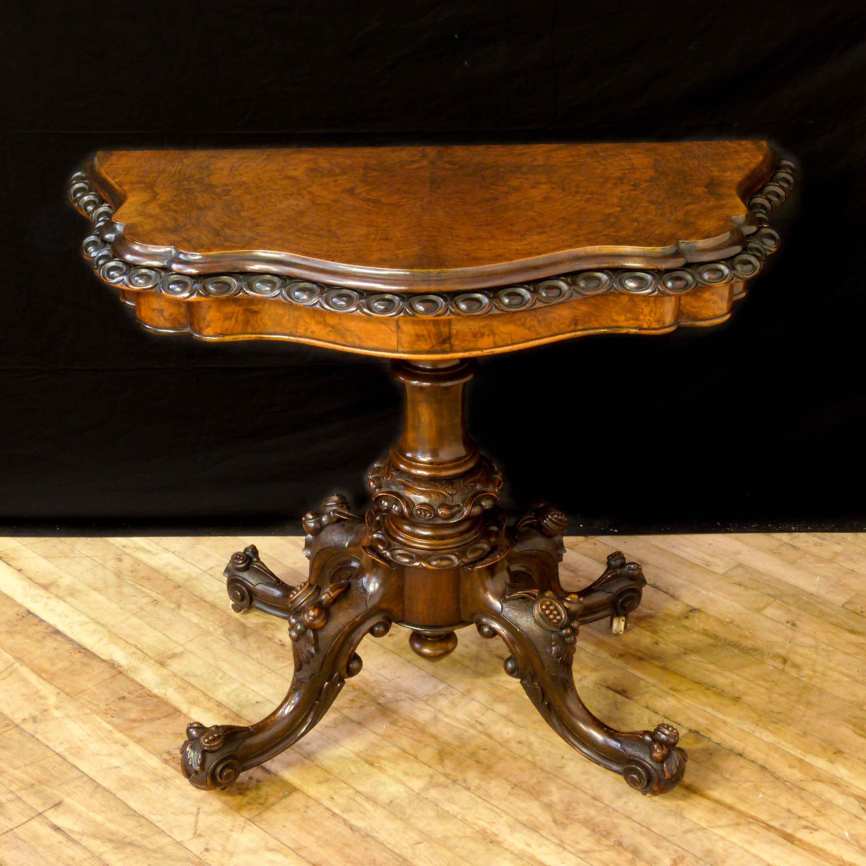This is a high quality piece of Victorian furniture. The cabriole legs are deeply carved with foliage and fruits still retaining the original castors. Set on a well turned central column which sets off the serpentine burr walnut top that is finely