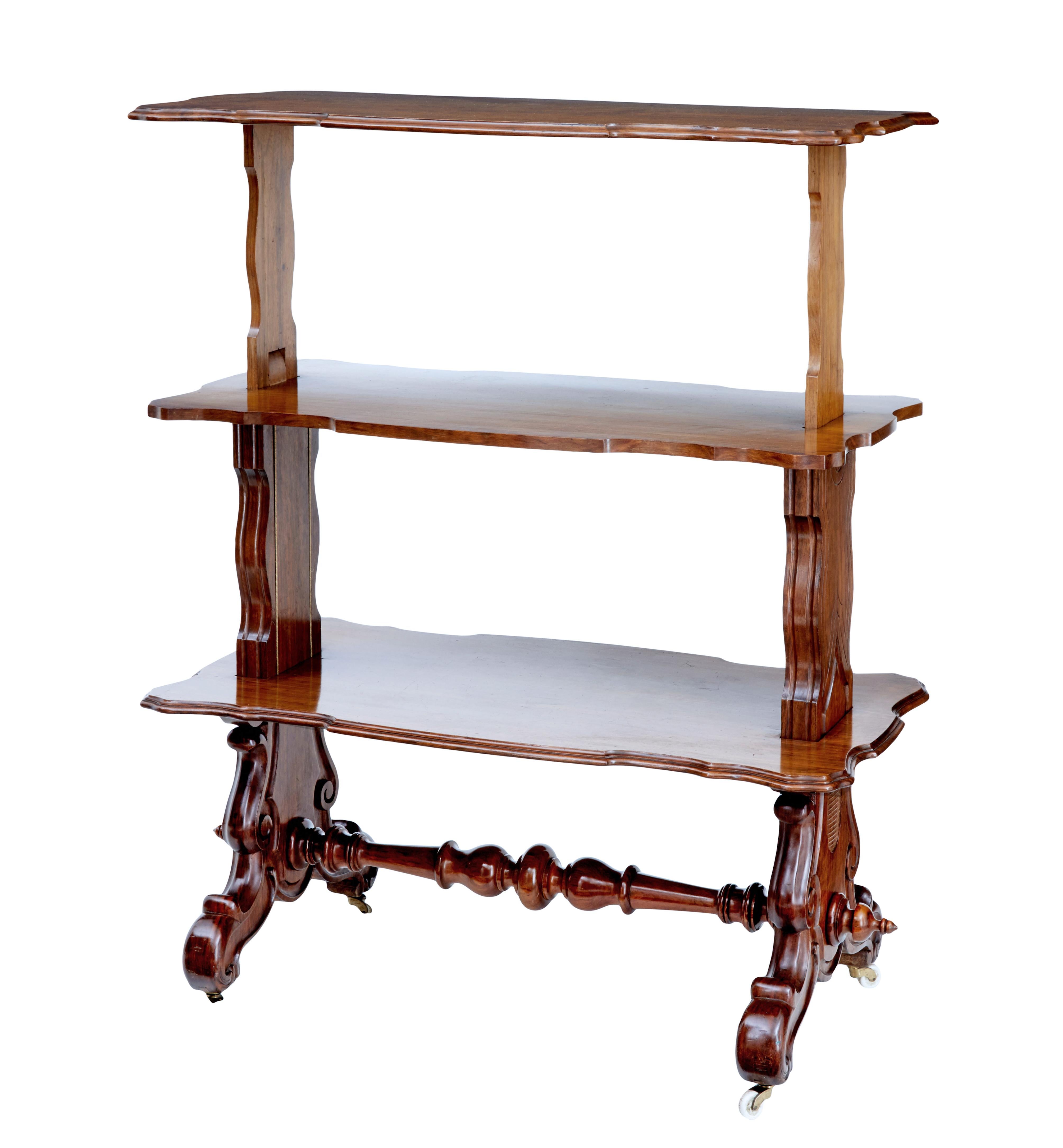 19th century Victorian walnut metamorphic dumb waiter, circa 1880.

Rectangular top with shaped decorative edging. Top rises up to form 3 serving surfaces. Carved trestle ends, united by turned stretcher.

Standing on ceramic castors.

Minor