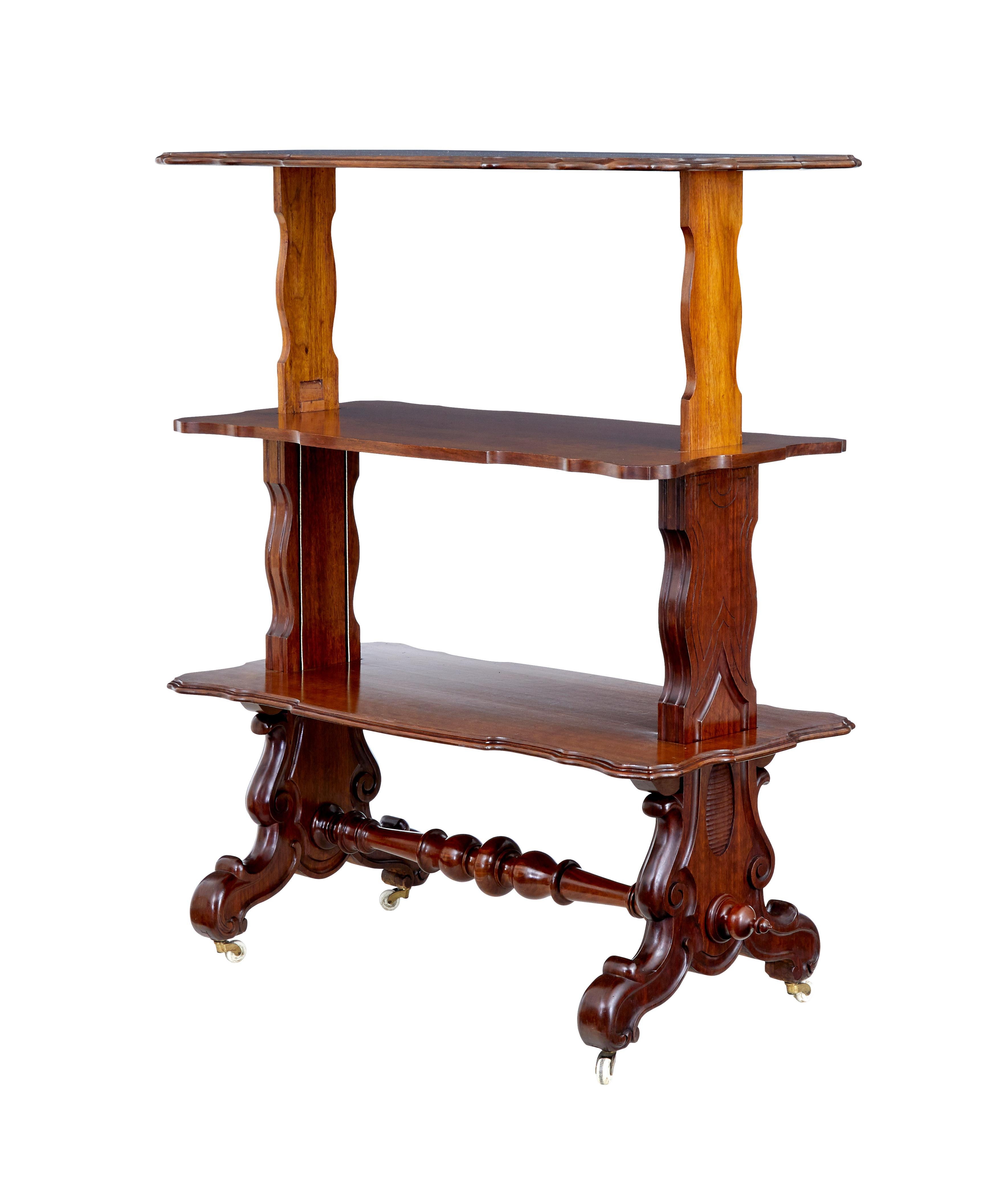 19th century Victorian walnut metamorphic dumb waiter circa 1880.

Rectangular top with shaped decorative edging.  Top rises up to form 3 serving surfaces.  Carved trestle ends, united by turned stretcher.  Tiers are pulled up and pushed down by