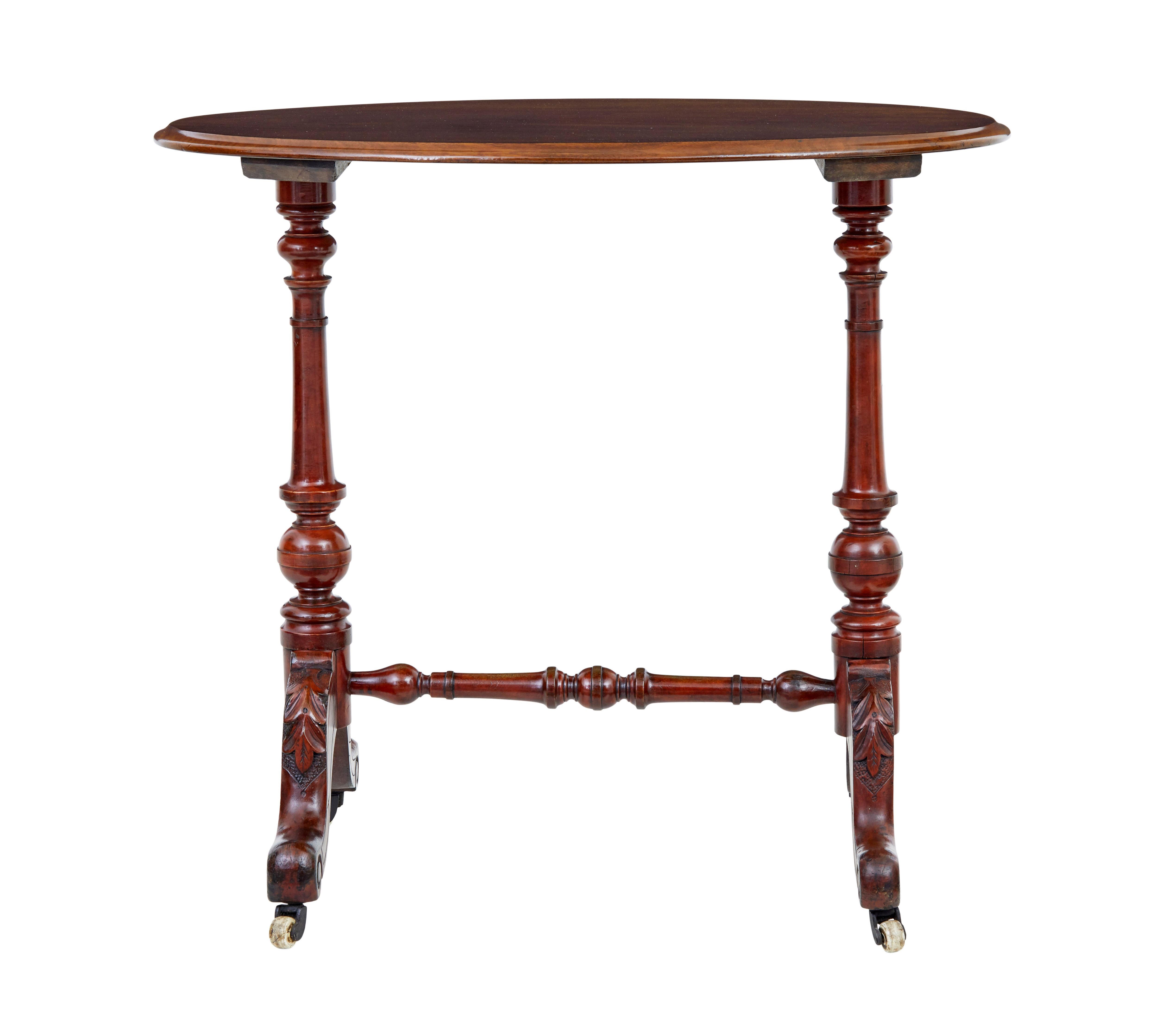 Pièce fonctionnelle de mobilier victorien vers 1870.

Plateau ovale en noyer, sur une base tournée typique de l'époque victorienne, avec des pieds à enroulement et des feuilles d'acanthe sculptées.  Monté sur des roulettes en céramique.

Idéal pour