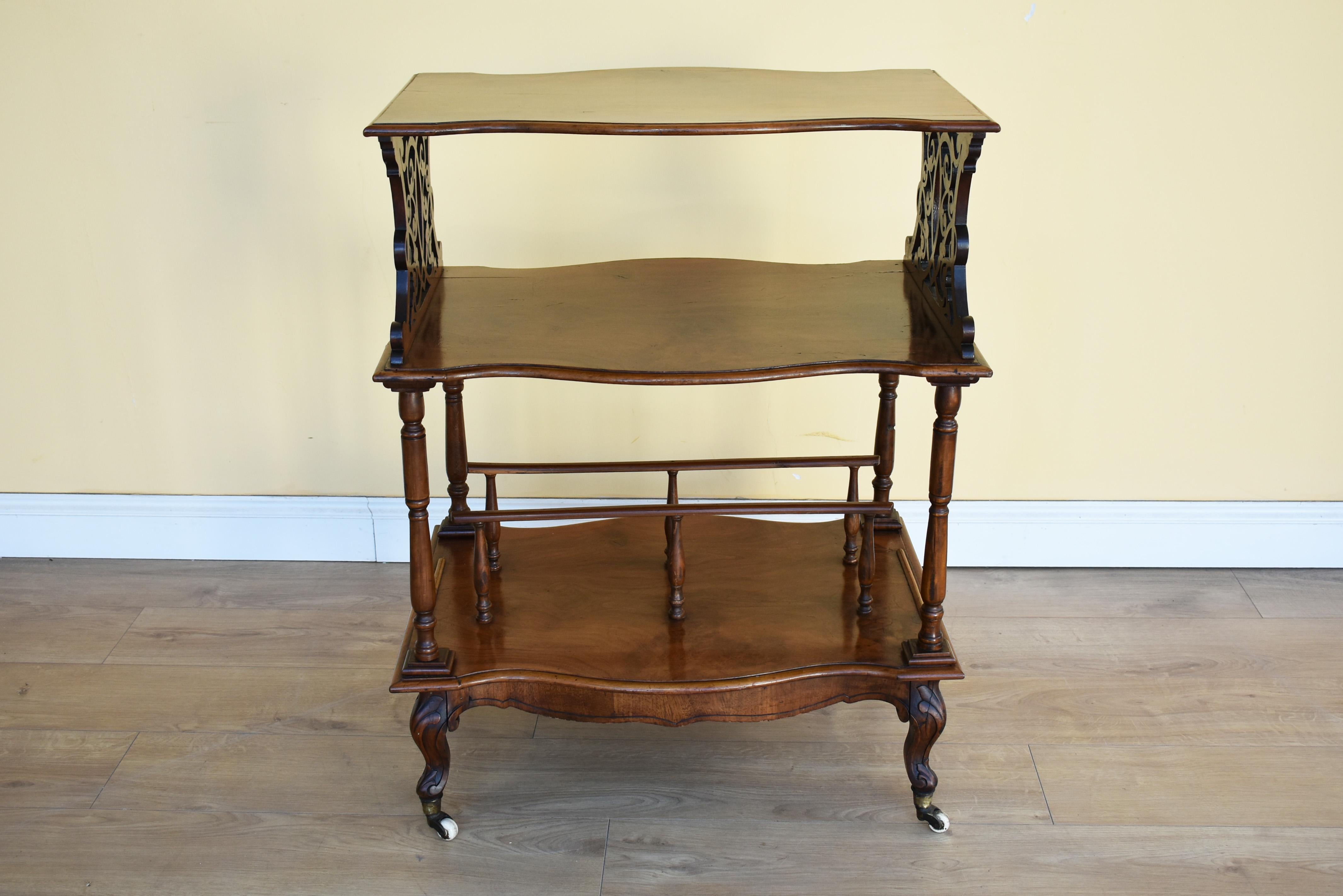 For sale is a good quality Victorian walnut what not, have a serpentine shaped top, supported by fretwork supports with a shelf below. Underneath this there is another shelf with two divisions, standing on small cabriol legs terminating on castors.