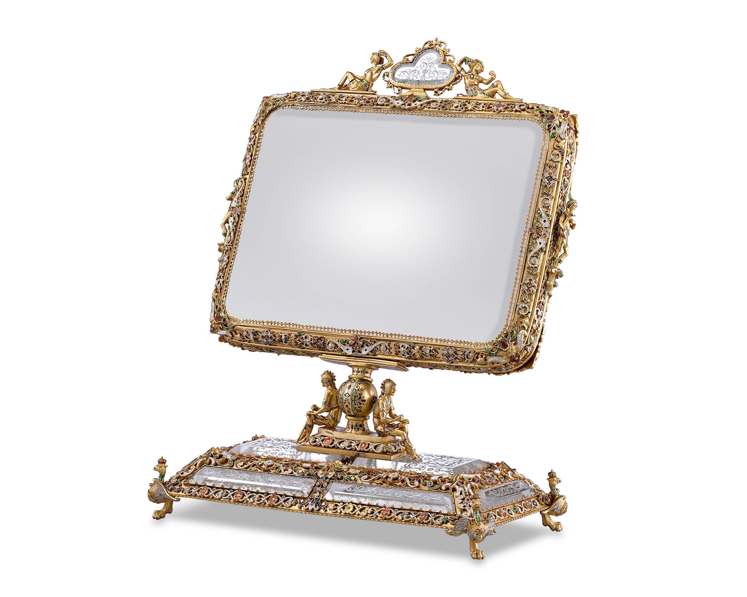 This magnificent Viennese mirror combines the mastery of the Viennese enameling tradition with the radiance of rock crystal. The silver gilt pieces are covered in a complex design of champlevé and relief enameling, while panels of intricately etched