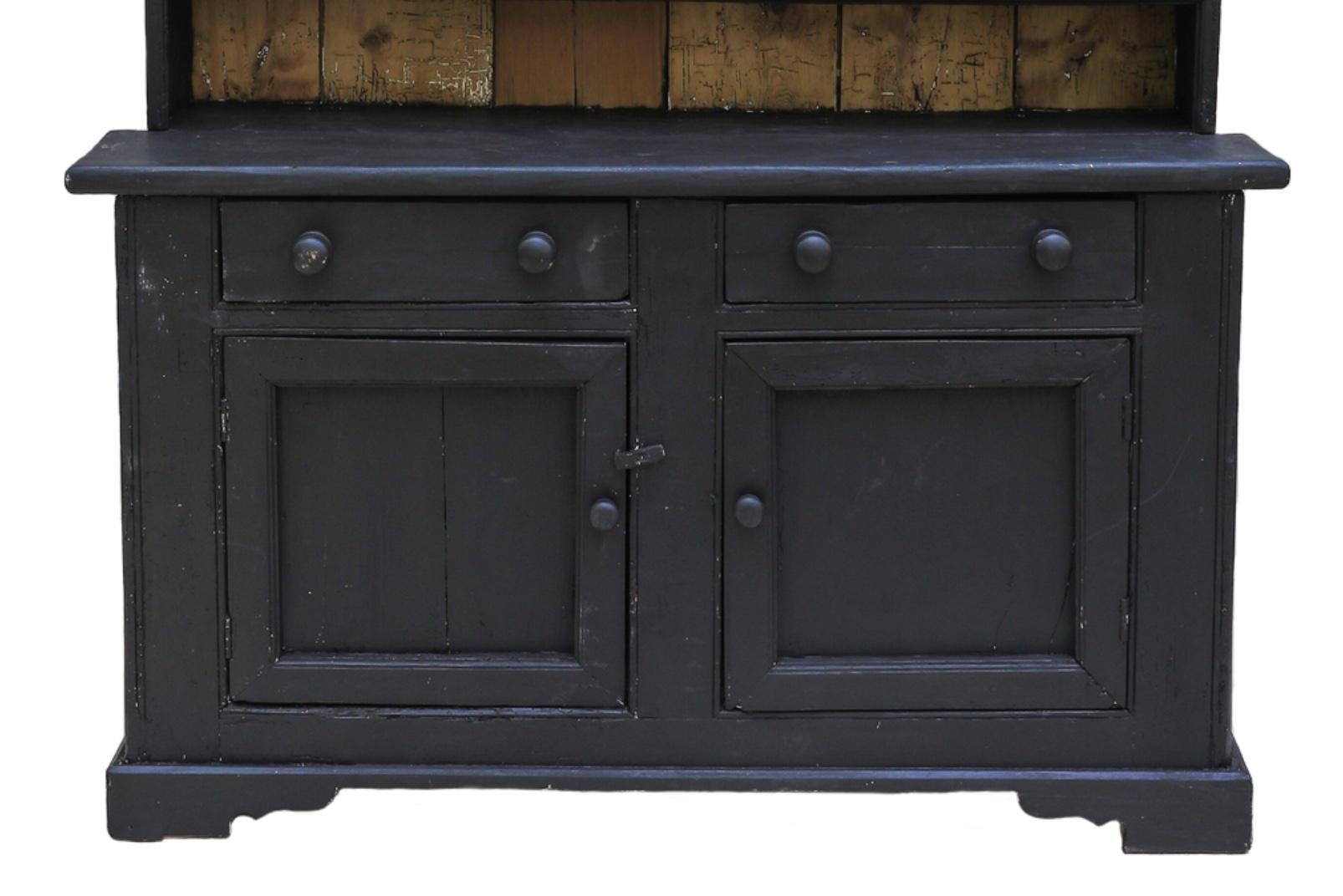 Presenting a quintessentially English hutch in a single-piece design, brimming with an abundance of color and character. This hutch proudly displays the charming signs of age, adding to its authentic appeal. Ebonized with a deep black hue, we hold a
