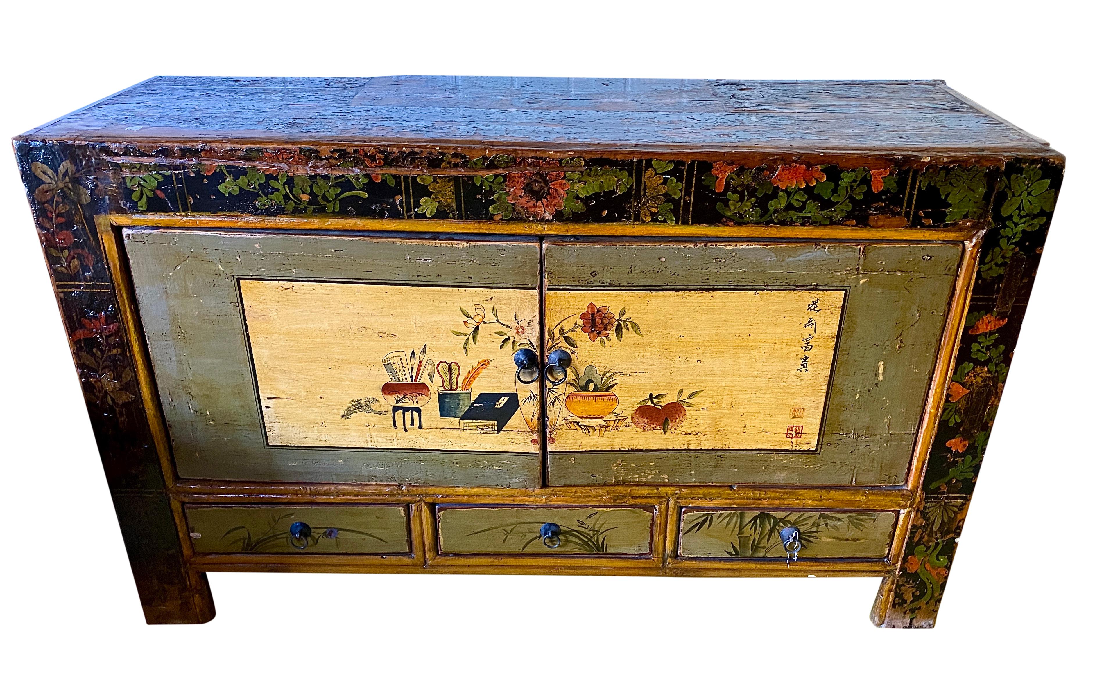 This 19th century vintage Mongolian hand painted cabinet features 2 doors opening to reveal two shelves with storage capacity. A great statement piece filled with art and history for the collector and the perfect home accent. The sideboard features
