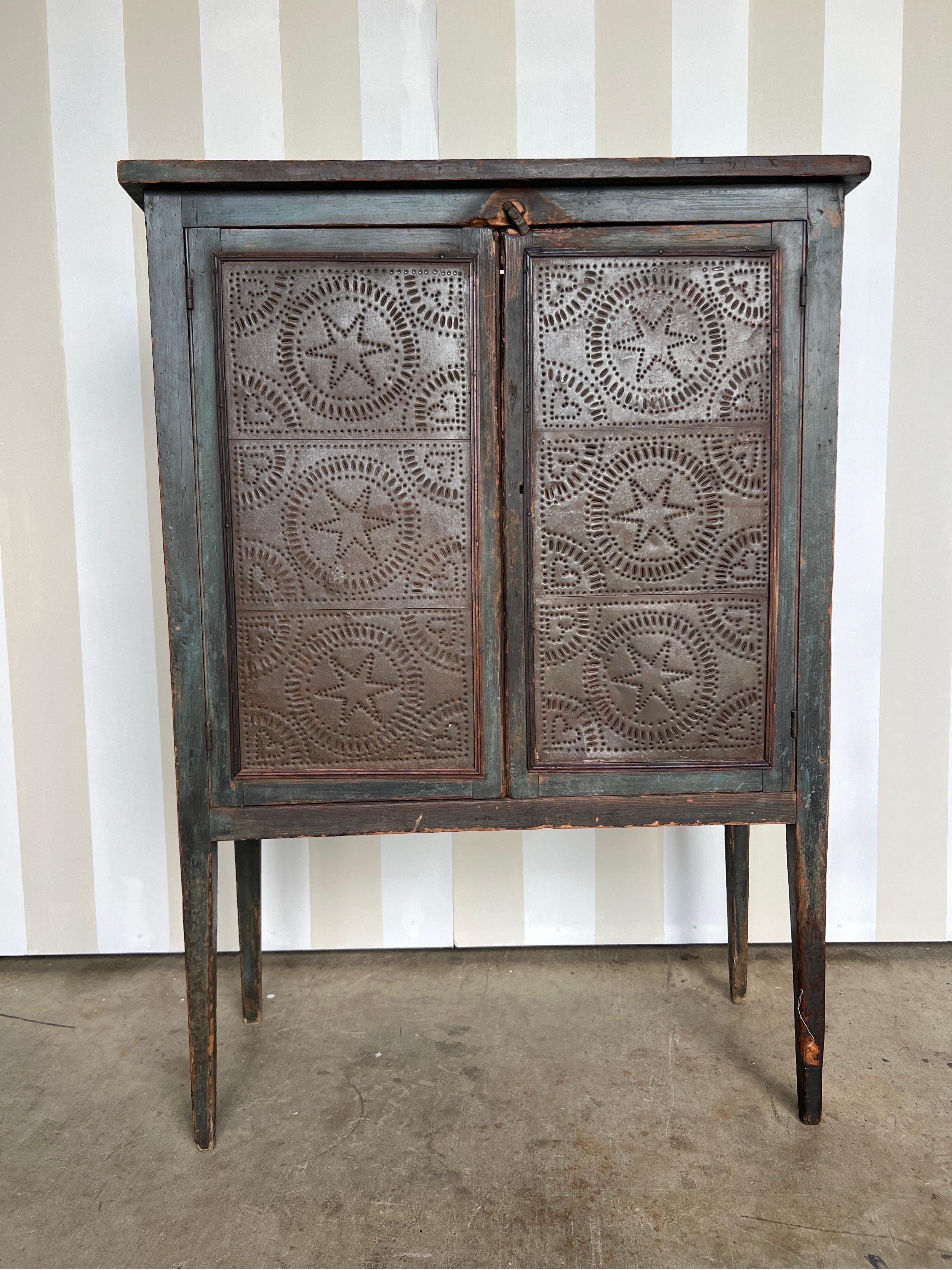 Bella cassaforte in pino della Virginia del XIX secolo con vernice blu originale. Tre ripiani coperti da ante con una meravigliosa patina e usura. Le lattine forate sono probabilmente dei ricambi di molto tempo fa. 