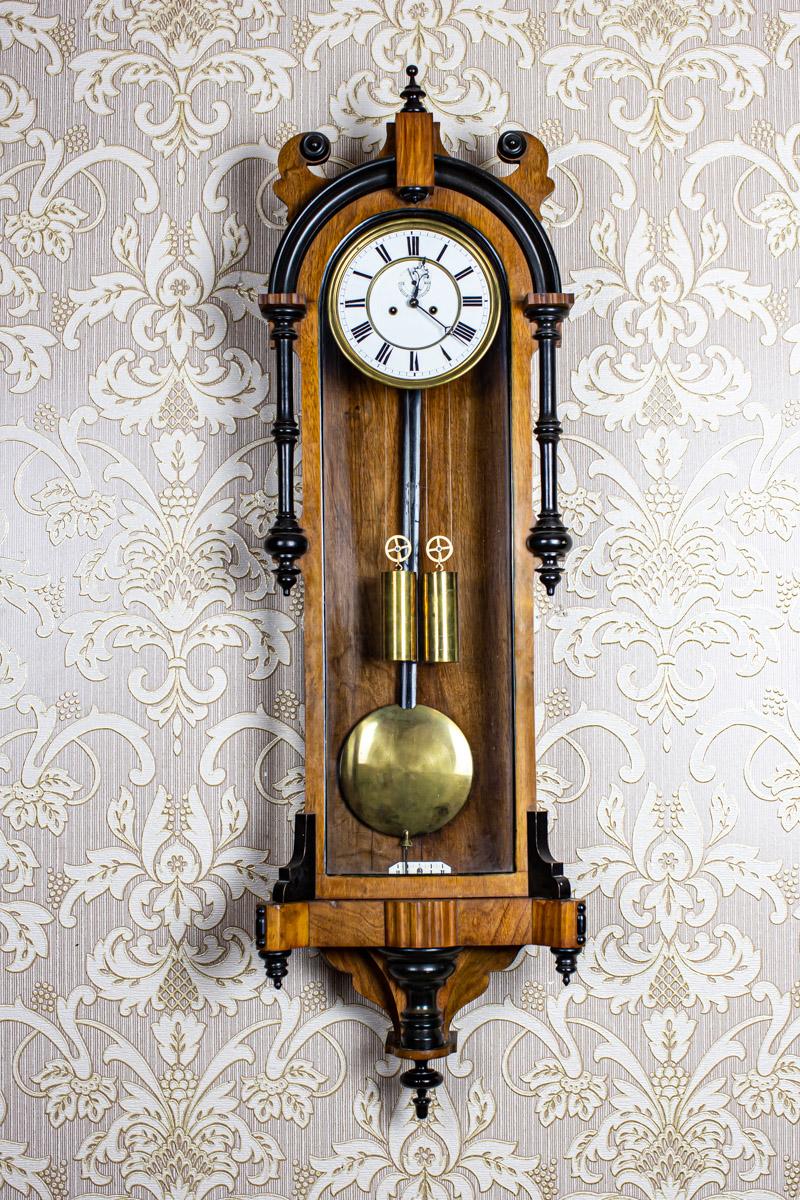 19th Century Wall Clock in Wooden Case with Interesting Frame

We present you this clock with a brass weight power source.
The wooden case is glazed on three sides.
Furthermore, the clock face is enameled with Roman numerals.

The clock strikes full