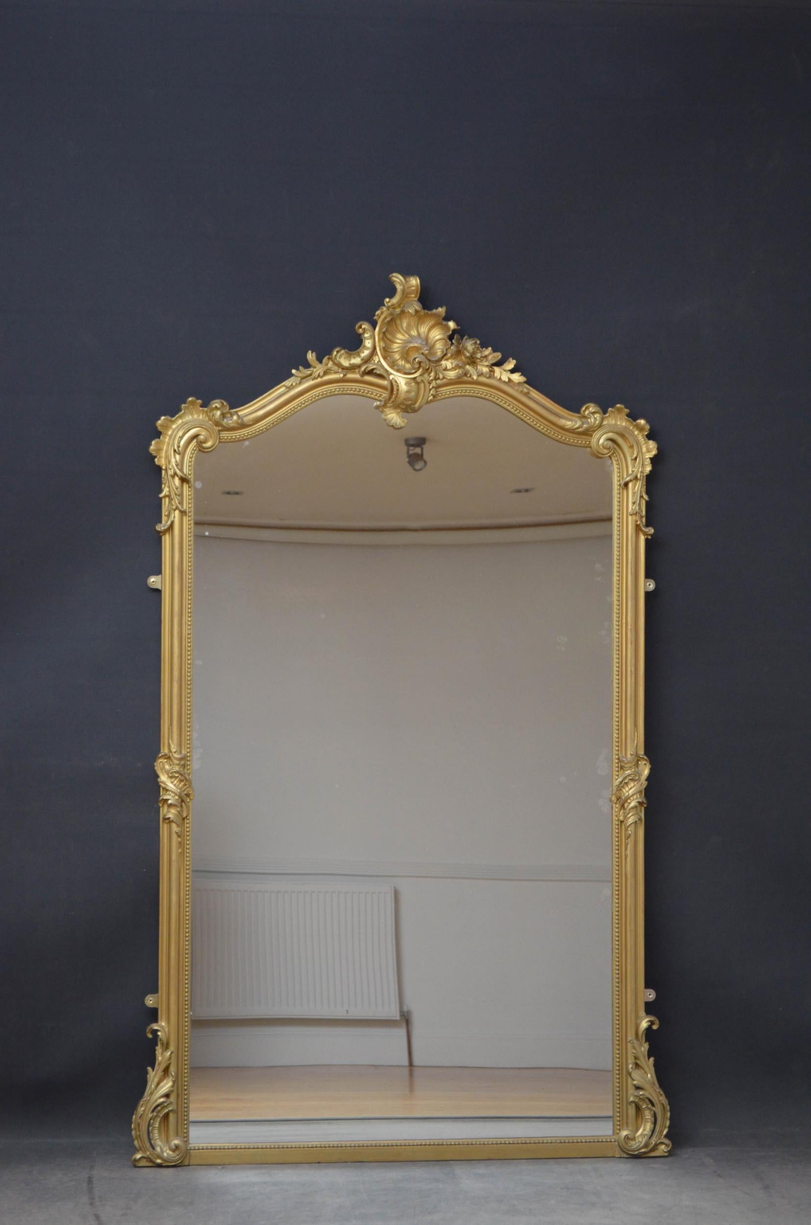 Sn4902 a large Louis XV style French giltwood wall mirror, having original glass with some imperfections in beaded, moulded and gilded frame with shell crest to the centre flanked by leafy scrolls to the top, centre and the base. This antique mirror