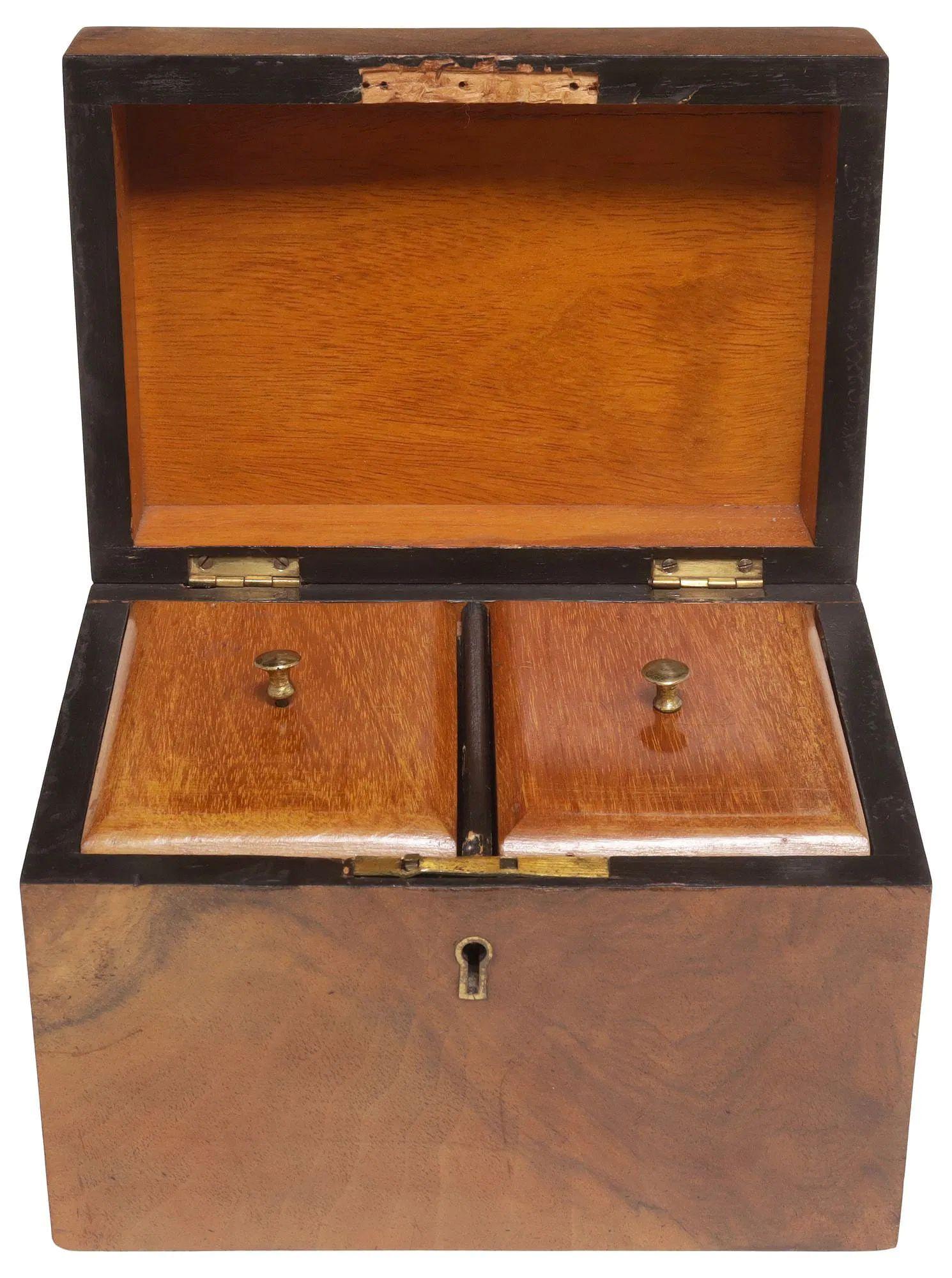 English figured walnut tea caddy from the 19th Century.  It has a rectangular form with a hinged lid and central shield formed brass cartouche.  It opens to two covered tea boxes.  A beautiful piece that will add warmth and charm to any room!