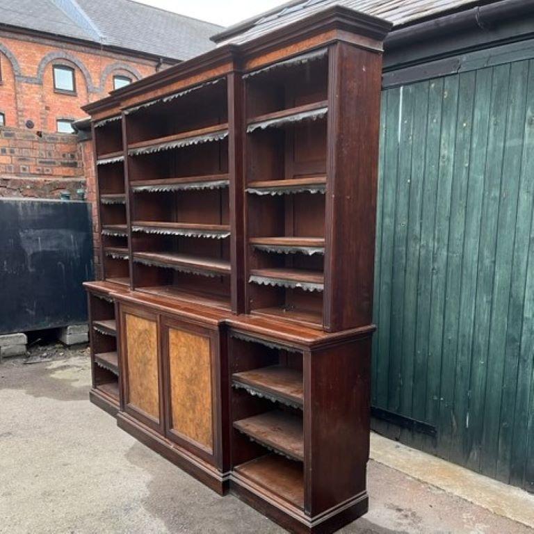 A 19th century walnut & burr walnut breakfront bookcase, the breakfront top with 12 adjustable shelves below a break-front burr walnut cornice frieze, the base with two burr walnut central panelled doors and two adjustable shelves either side,