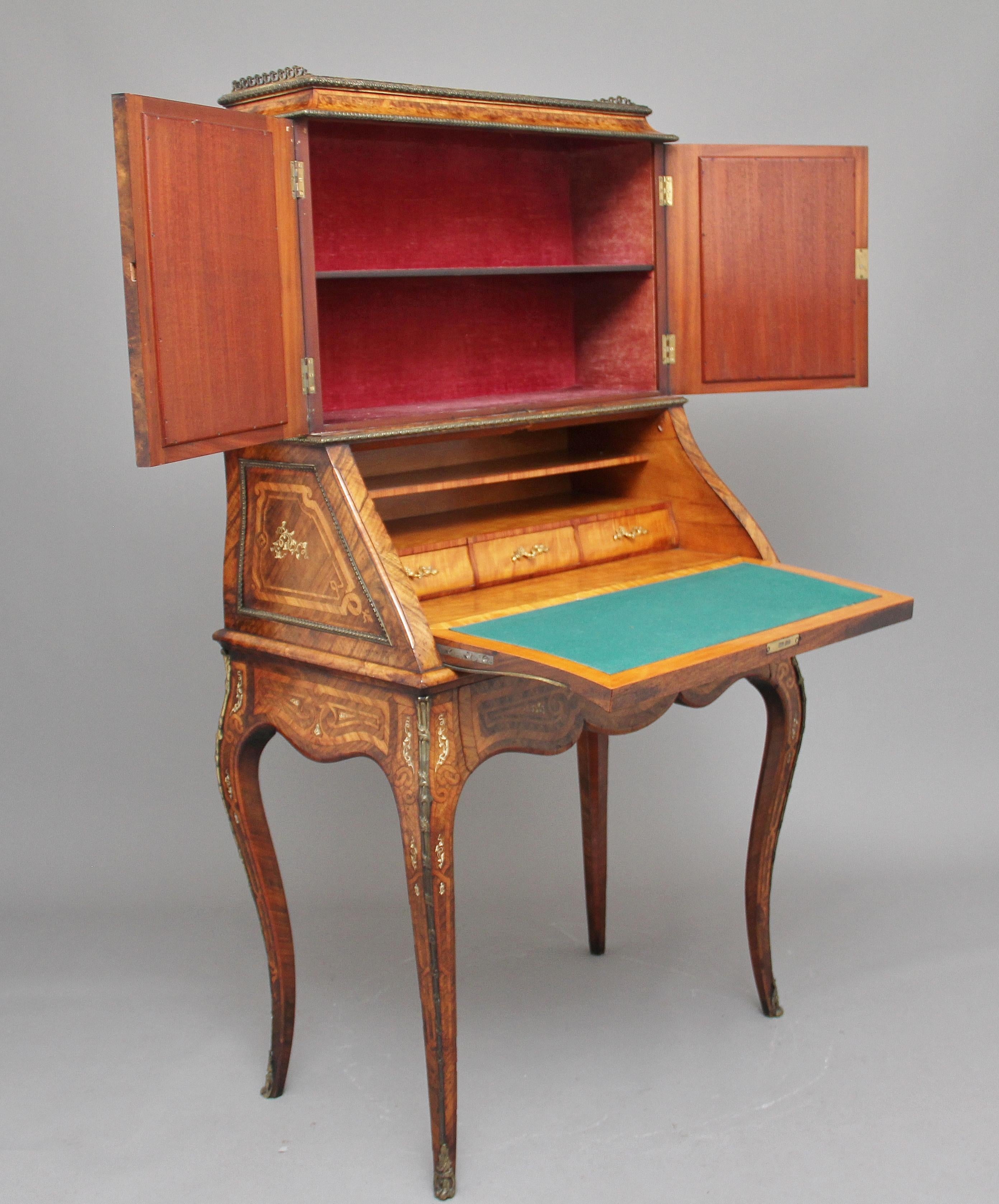 19th century French walnut and kingwood bureau de dame, the rectangular top decorated with brass gallery, carved ormolu moulding below on the top and bottom of the frieze, the top section having two mirrored glass doors with ormolu moulding, opening