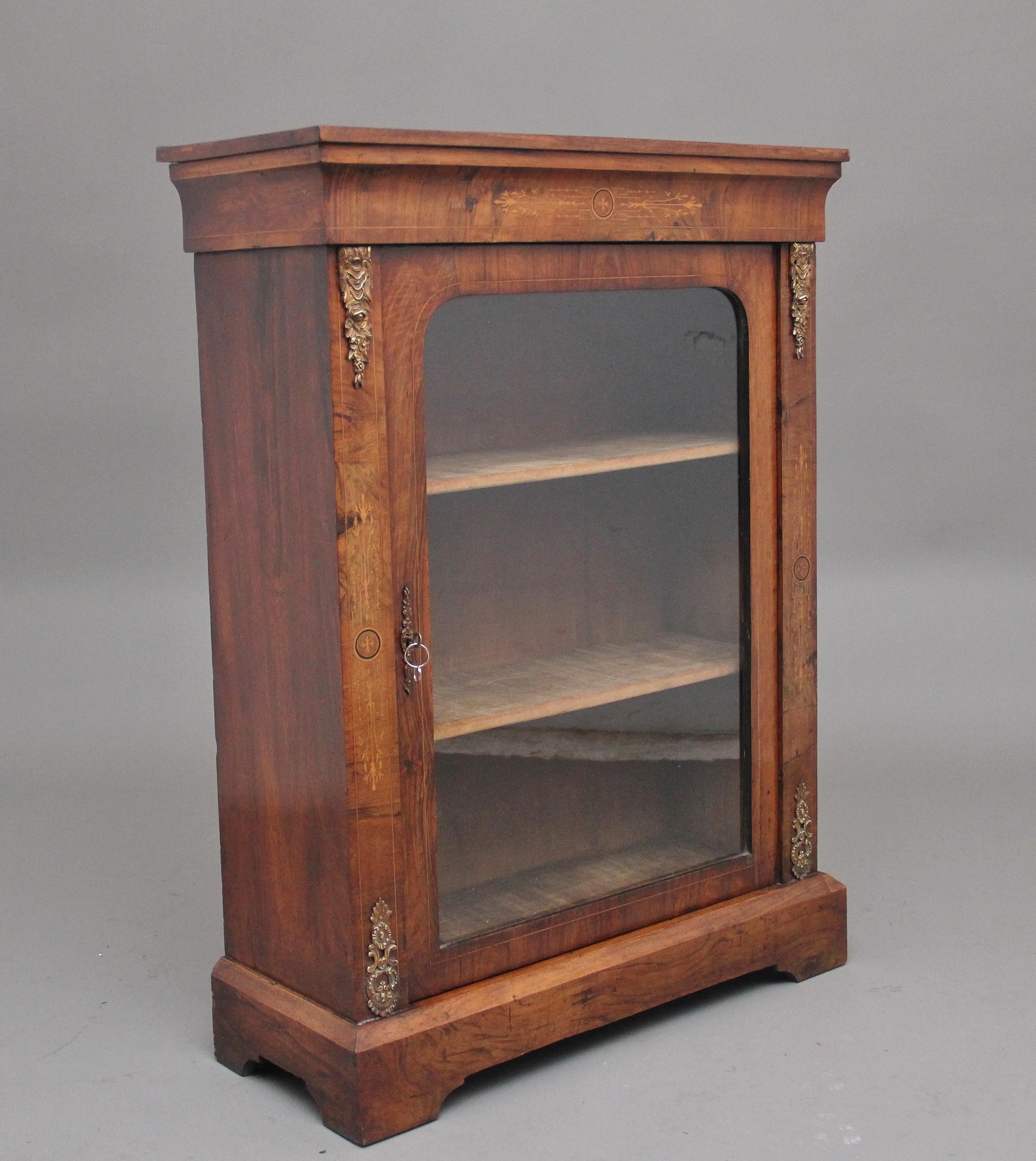 19th Century walnut and marquetry pier cabinet, having a nice figured stepped and moulded edge top above a marquetry inlaid frieze with decorative inlay, a single glazed door below opening to reveal two fixed shelves, either side of the door having