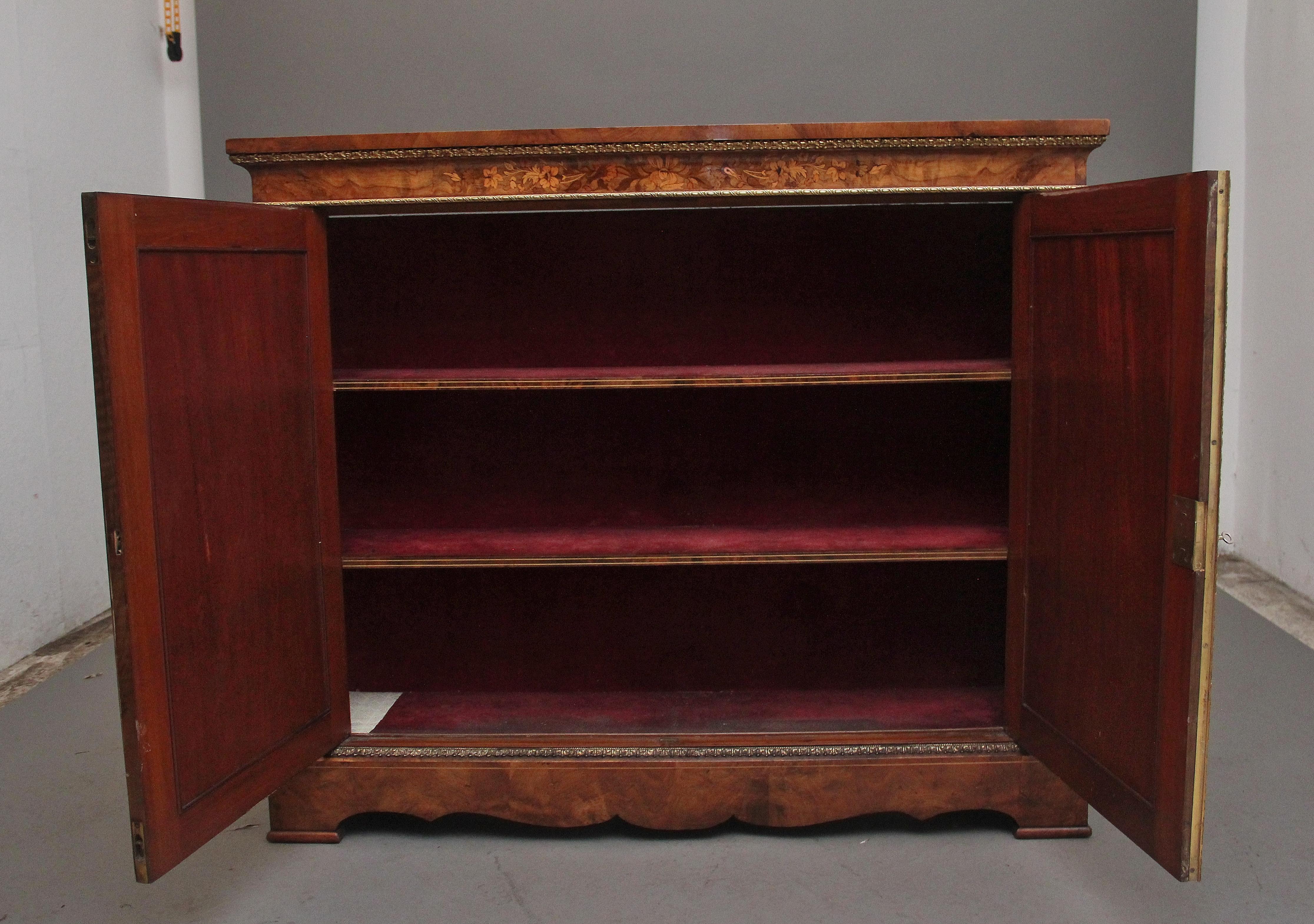 Un favoloso mobile a due ante in noce e intarsio del XIX secolo,  con un meraviglioso piano figurato sopra un fregio con modanature in ormolu e decorato con intarsi floreali, due ante a pannello incernierate che si aprono per rivelare un interno