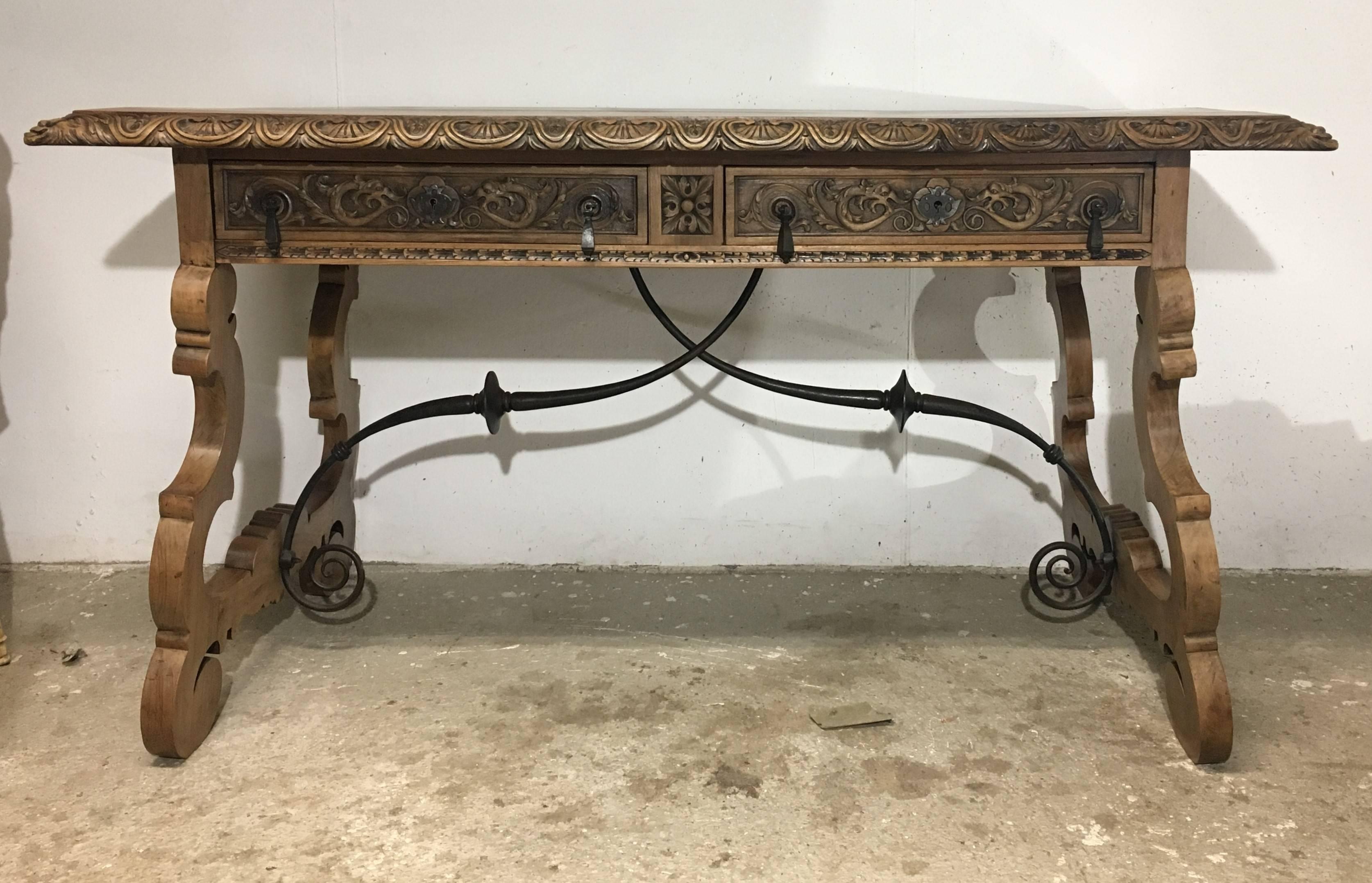Spectacular 19th century walnut and wrought iron desk with two drawers. Beautiful unique brass metalwork on both drawers. A Brutalist wrought iron stretcher connects two pedestals lyre legs a hand-wrought iron.
All the four sides are carved, it´s