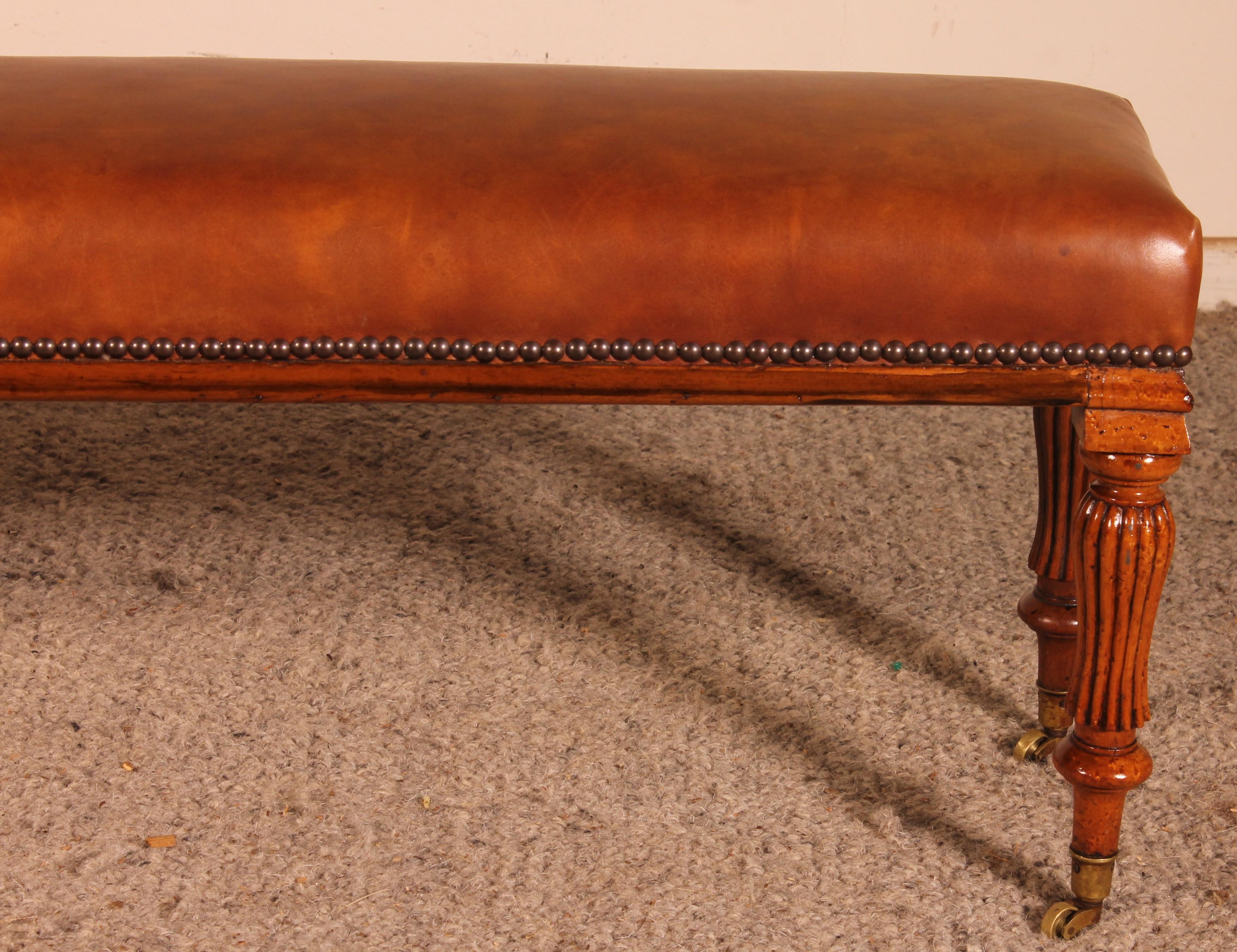 a fine 19th century walnut bench from England.

Very beautiful walnut base ending with castors.
The bench has been covered with a cognac leather which has a very beautiful patina.
Unusual small model and beautiful proportions.