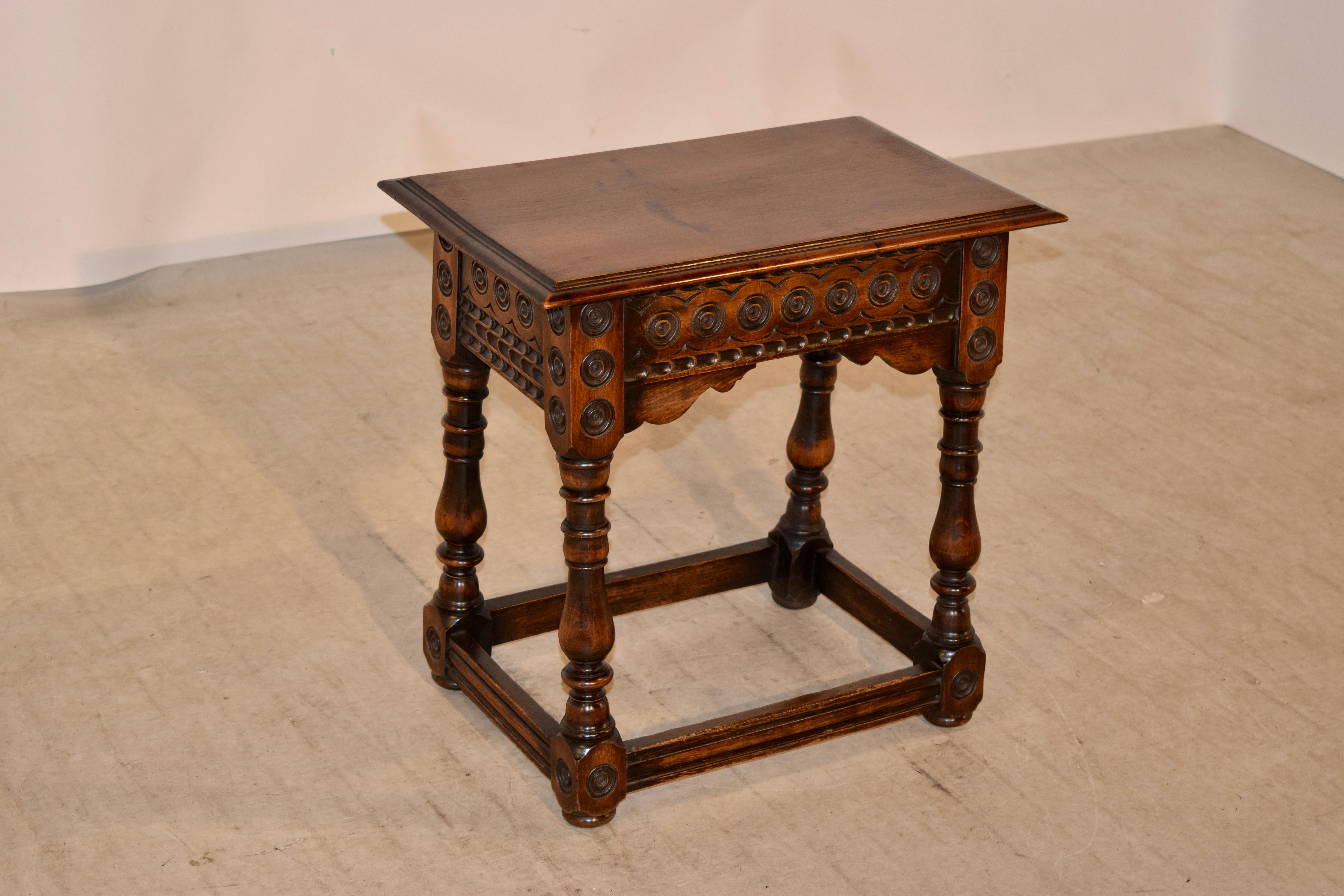 19th century hand carved decorated stool from France. The top has a beveled edge and follows down to a lovely hand carved decorated apron with hand scalloped brackets. The stool has wonderfully hand-turned and splayed legs joined by routed decorated