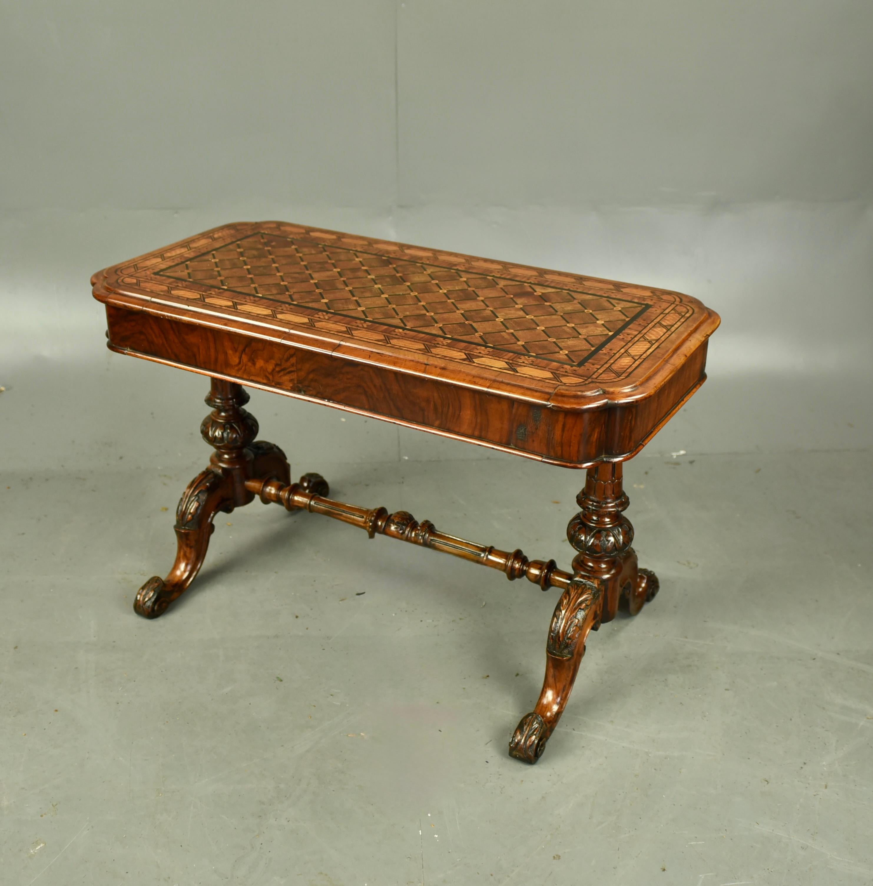 Fine quality Victorian inlaid walnut coffee table .
The coffee table has a wonderful inlaid top with cross grained mouldings .
It stands on a wonderful carved walnut base with a fluted and carved column each end with four folate carved feet .
It is