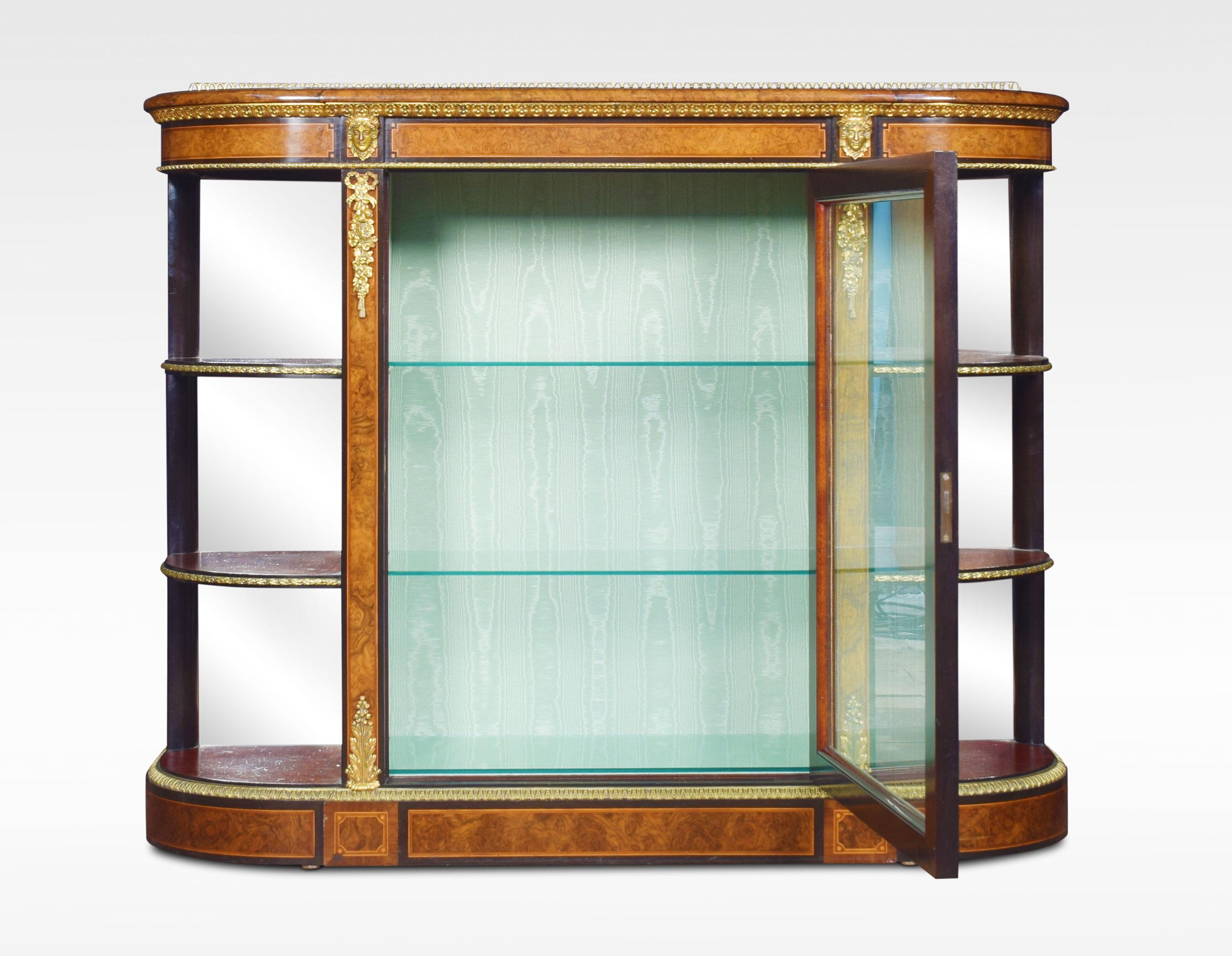 19th century figured walnut and ormolu-mounted credenza, the well figured top over ormolu mask mounts and acanthus banding, with a central glass door enclosing watermark silk-lined interior and two glass shelves. Flanked either side by open shelves