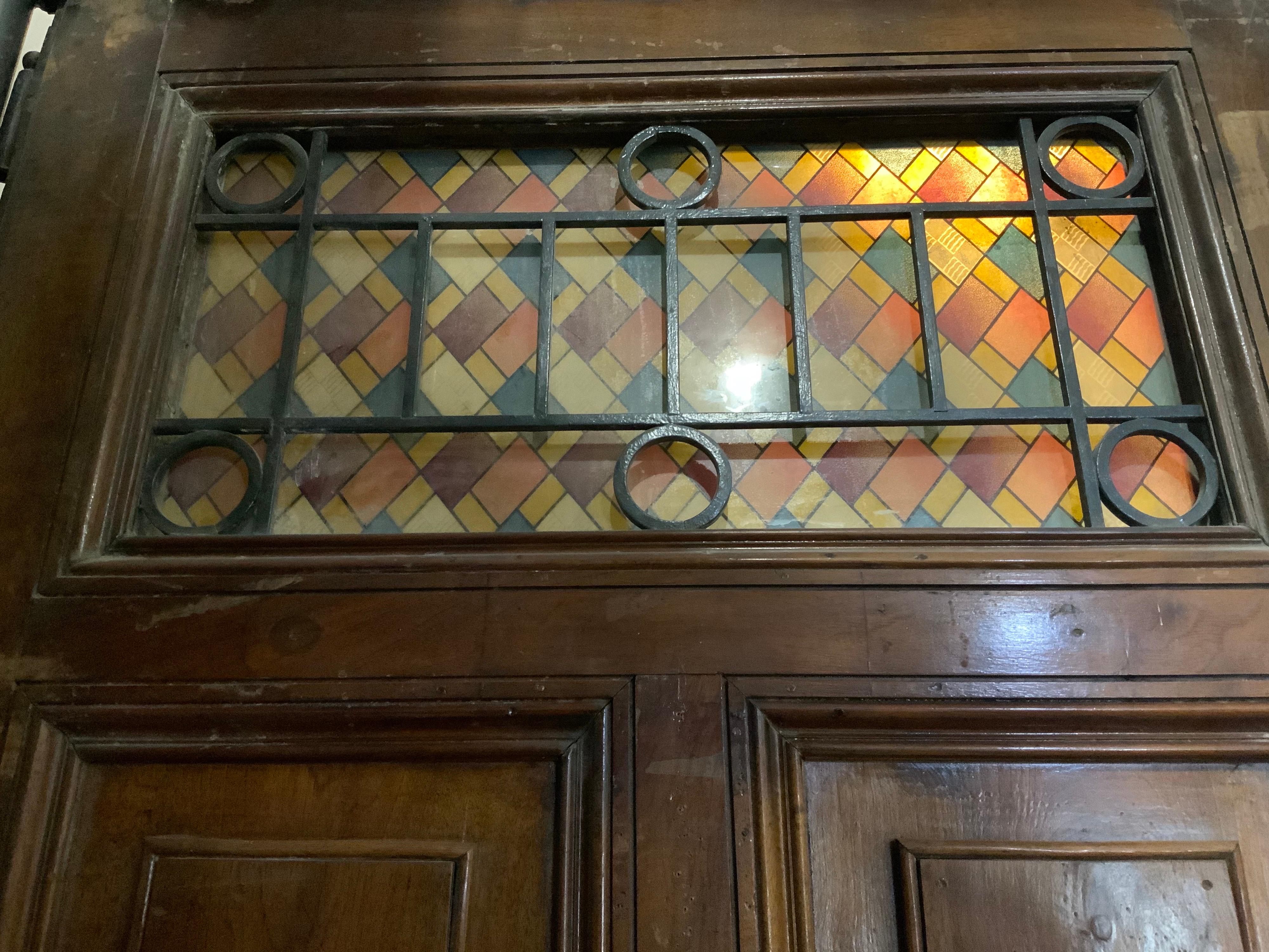 This walnut door origins from France, circa 1880.

It has a beautiful colorful stained glass.
