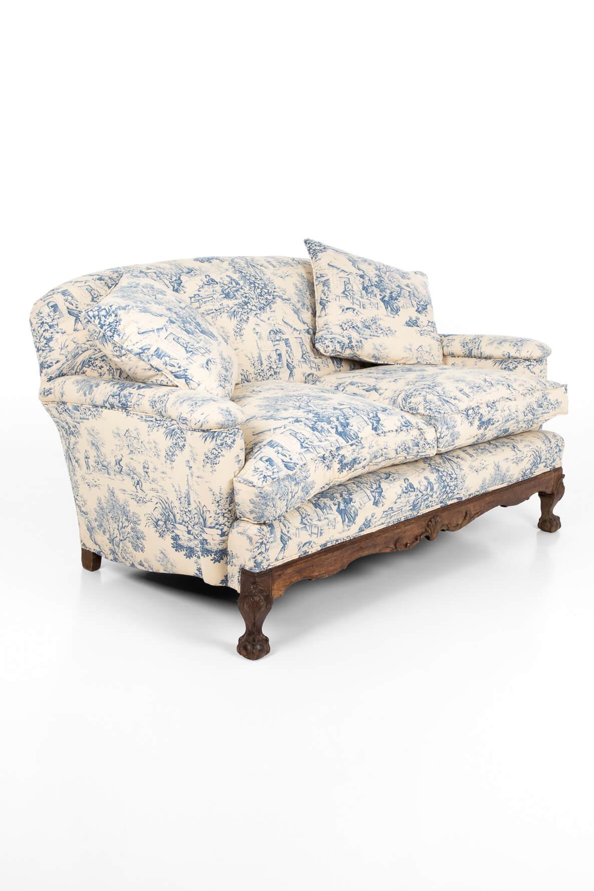 A wonderful late 19th century walnut framed sofa, with claw and ball feet over a humpback frame. Generously proportioned and immaculately presented in Toile de Jouy fabric, displaying romantic and pastoral patterns. The sofa has been fully restored