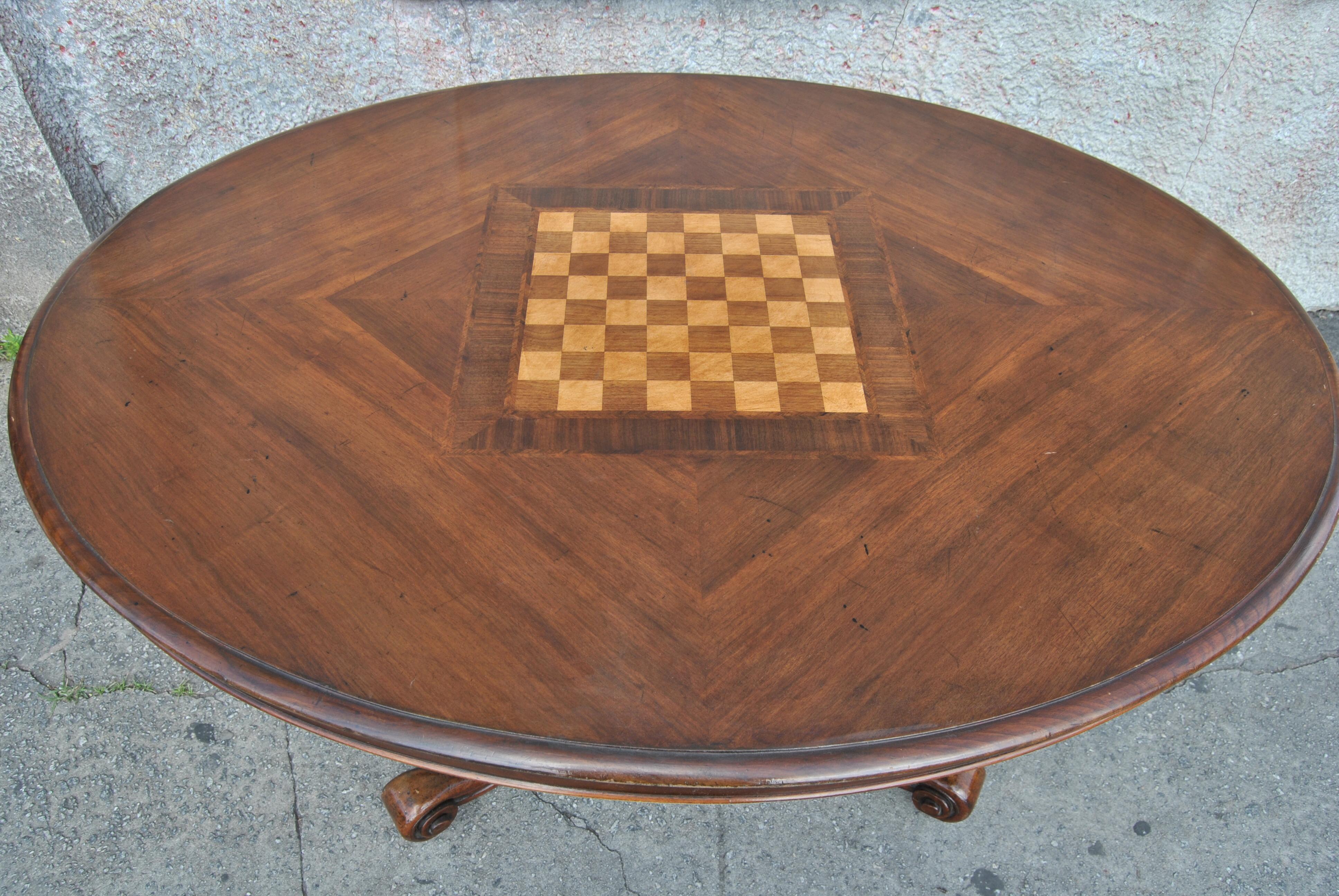 This is a walnut tilt-top table / games table / chess table / breakfast table made in England, circa 1860. The top has a beautiful grained walnut set in quarters with a games / chess board to the middle. There is an inlaid herringbone walnut banding