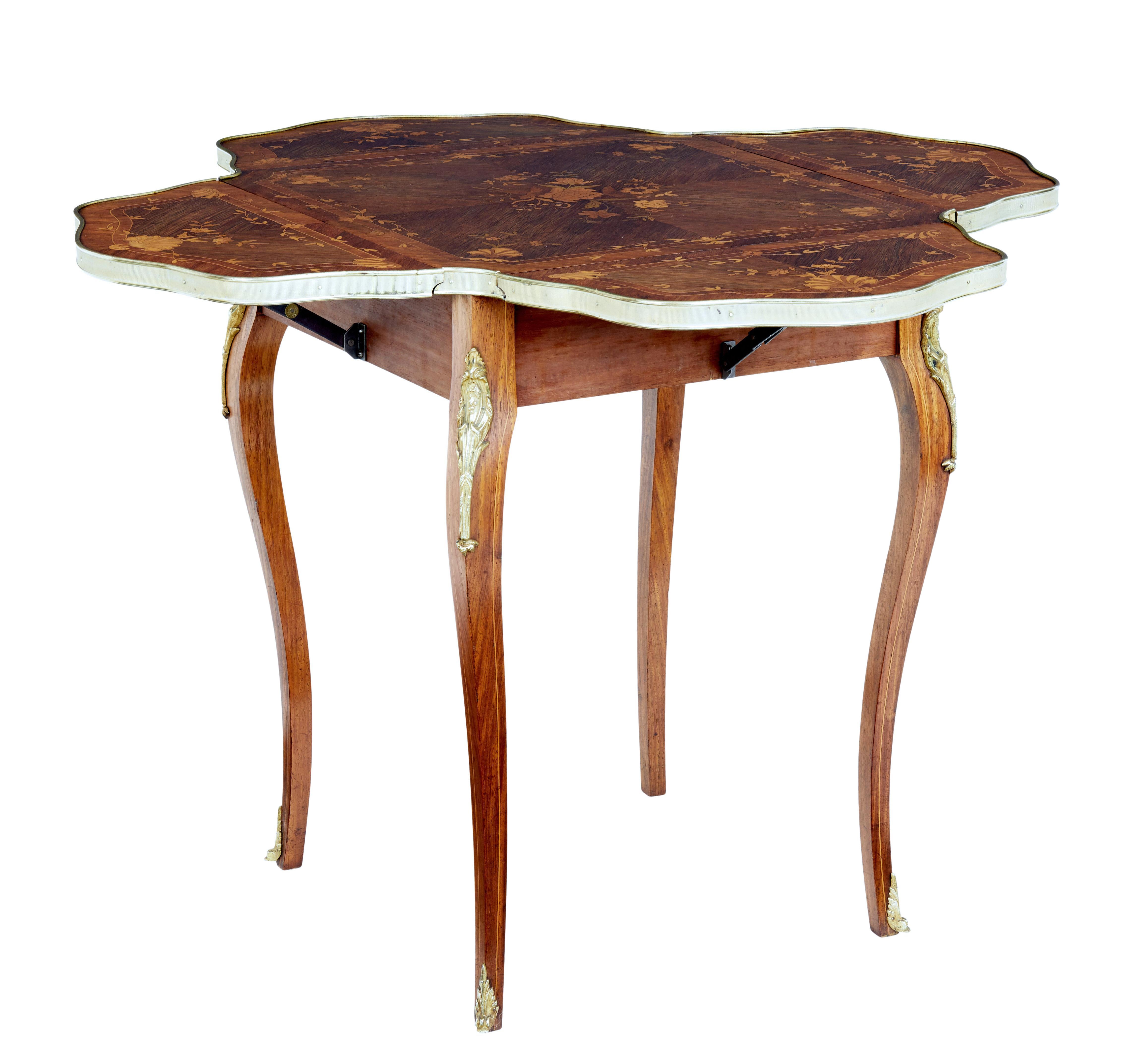 Good quality Victorian envelope occasional table, circa 1890.

Square top with 4 shaped drop down leaves on each corner, beautifully inlaid with palisander, satinwood and boxwood. Complete with strung borders. Top edge with machined brass border