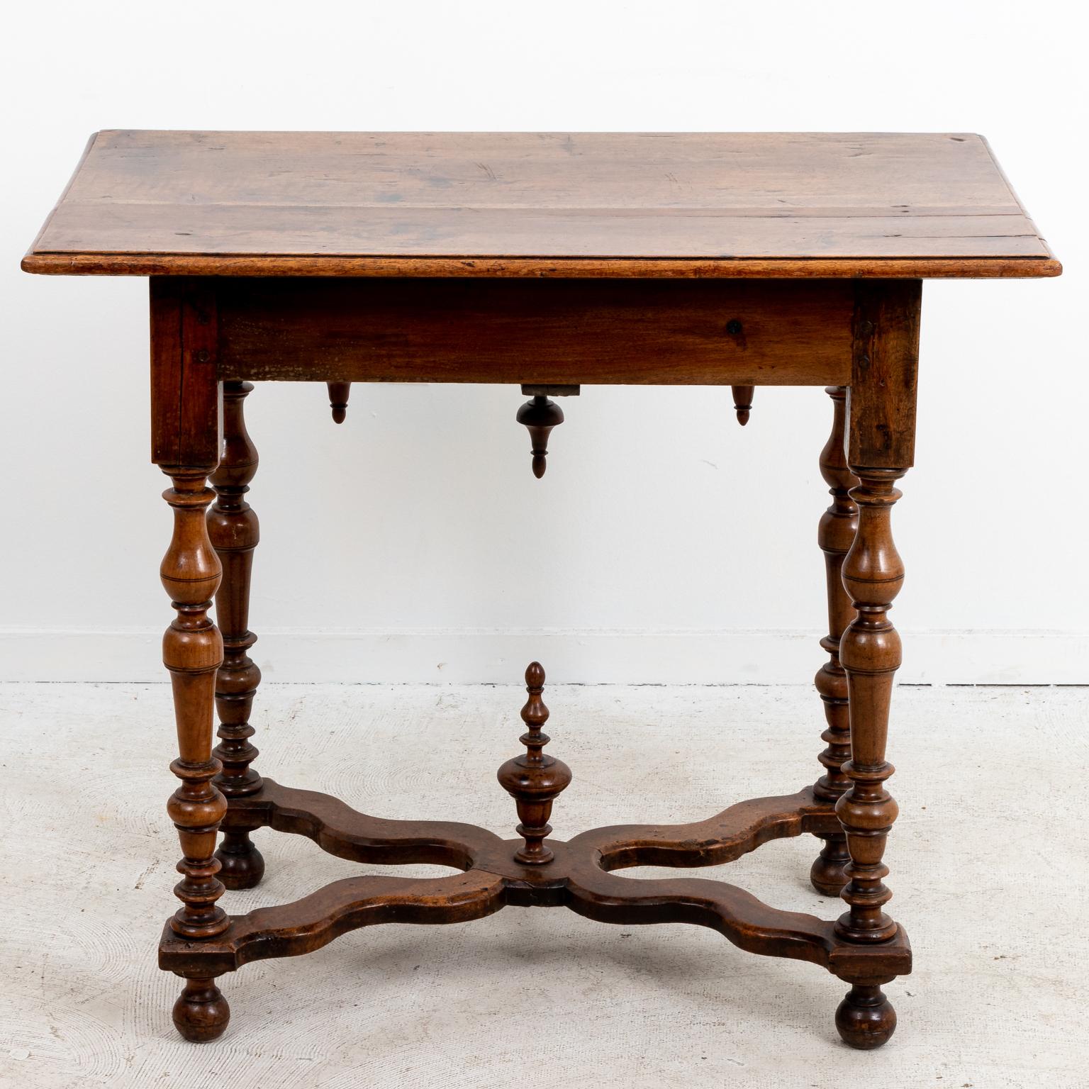 Jacobean style walnut table with single drawer and curved skirt accented by pendant finials, circa 19th century. The base also features vase-and-ring turned legs on ball feet, bottom X-shaped cross stretcher, and large finial at the center of the