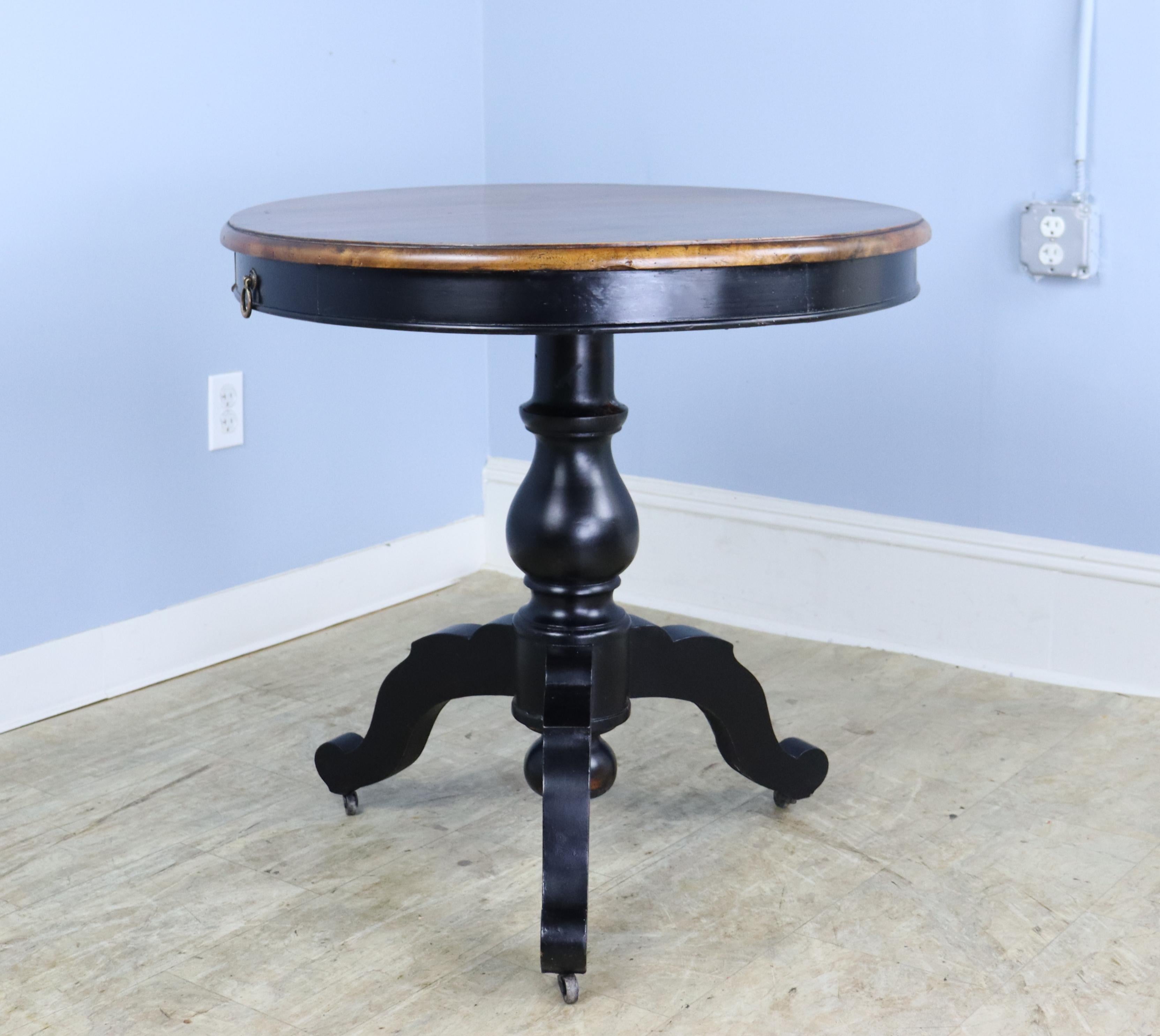 Good looking tripod based French lamp table with a stunning walnut top. Ebonized base has some interesting wear. Two hidden drawers.